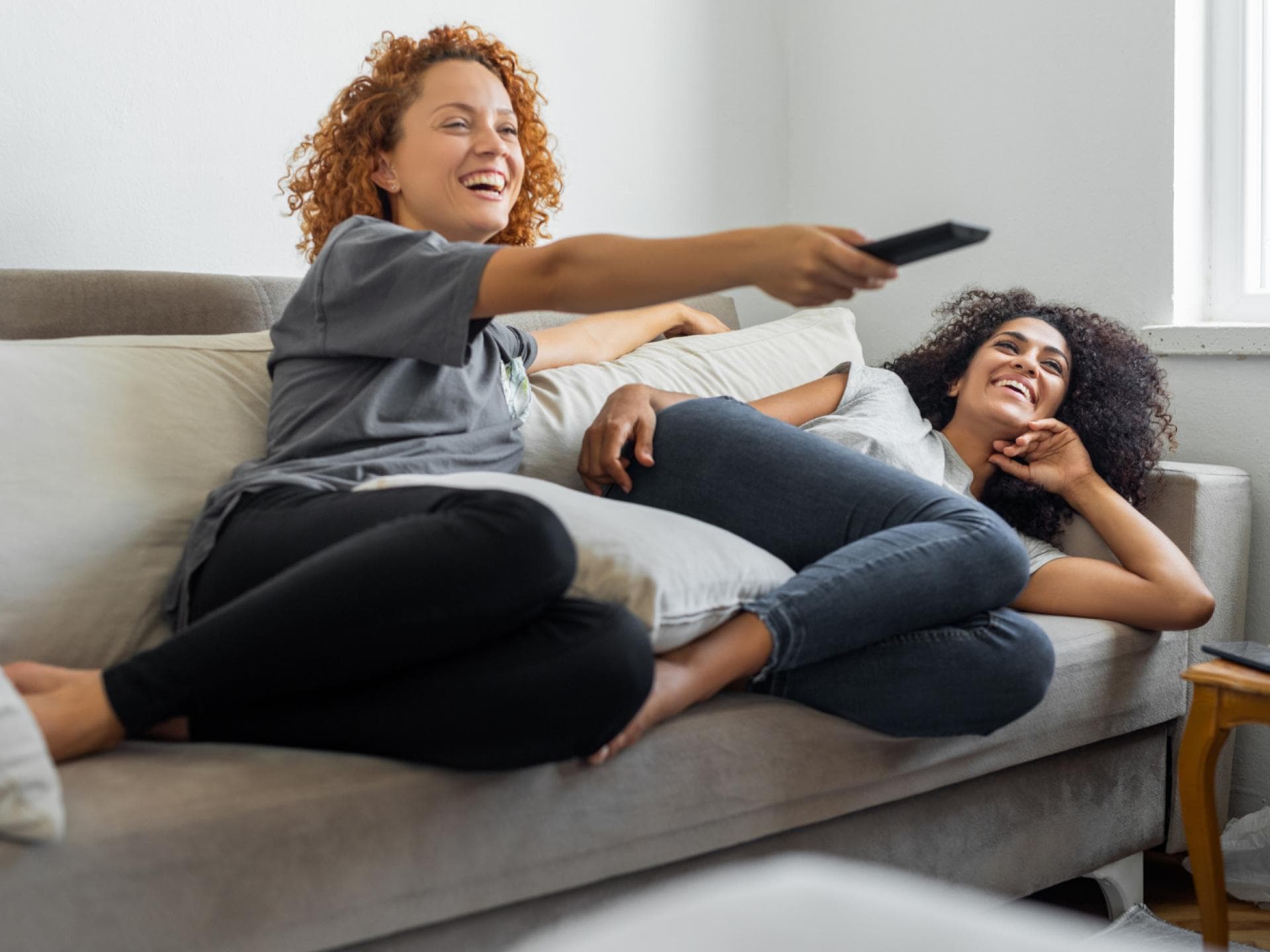 Fernsehen schauen zwei Frauen Couch Fernbedienung
