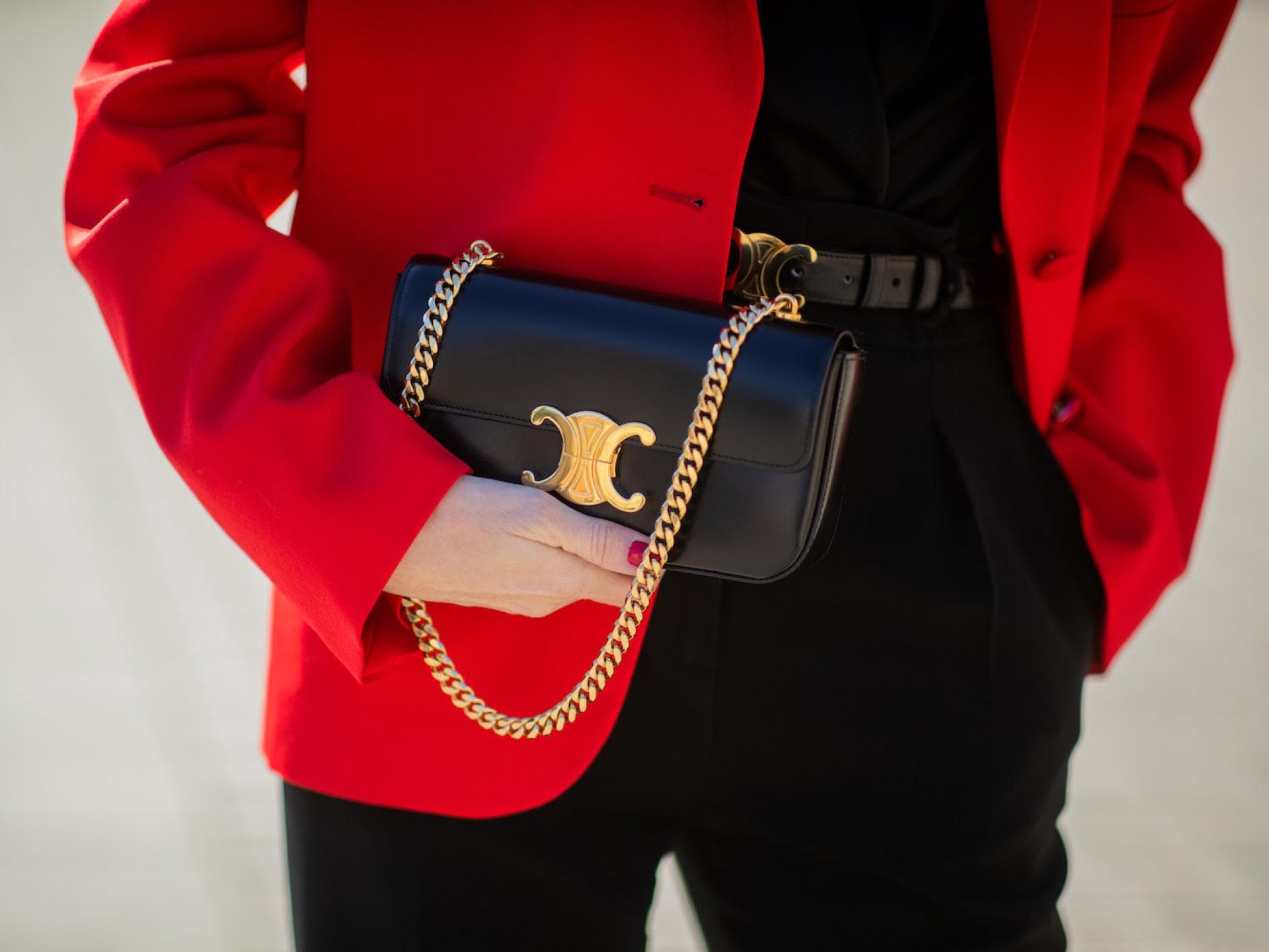 Frau mit rotem Blazer und schwarzer Celine Triomphe Tasche