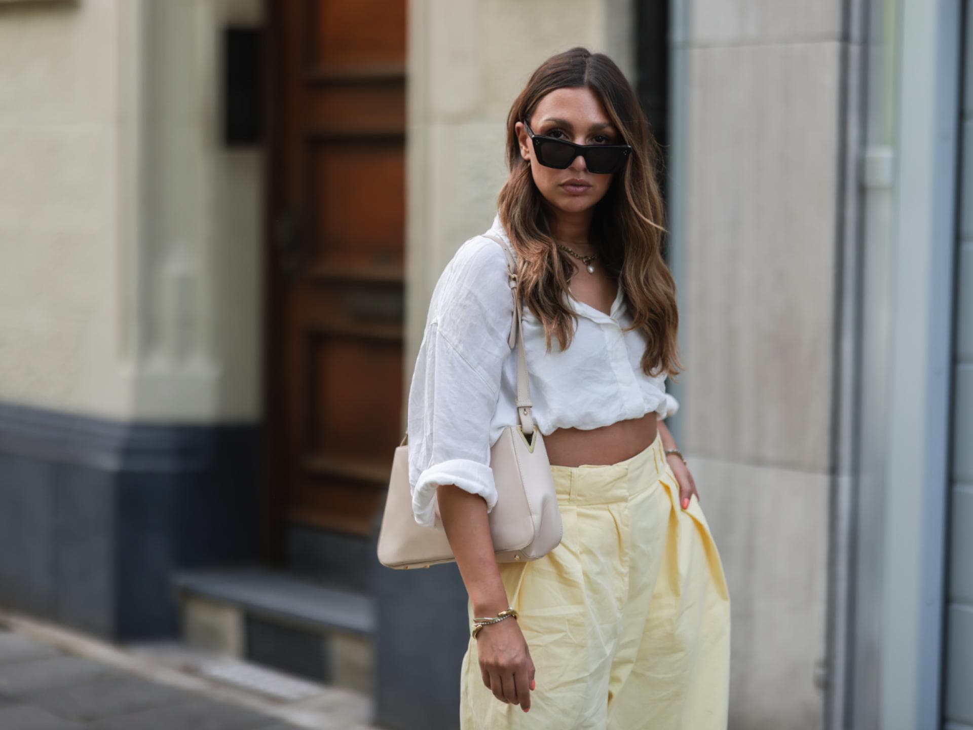 Kira Bejaoui trägt weiße Bluse Sonnenbrille beige Tasche Streetstyle