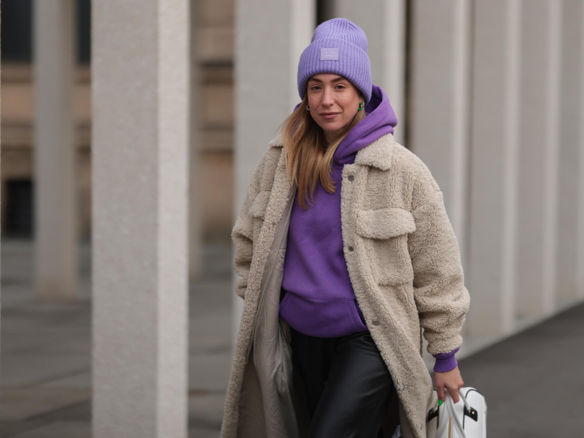 Sonia Lyson trägt lila Hoodie Mütze Mantel Streetstyle