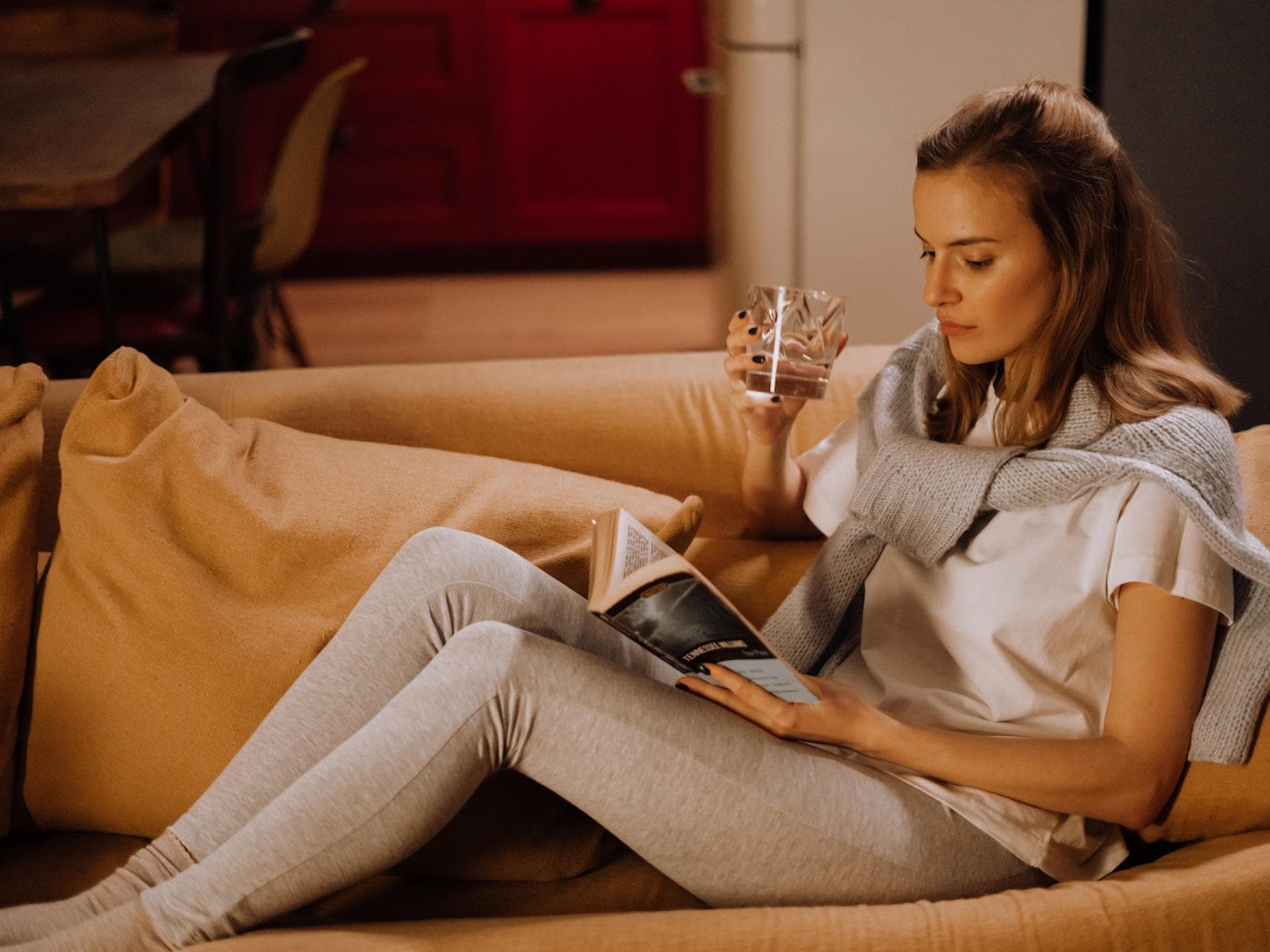 Frau liest Buch auf dem Sofa