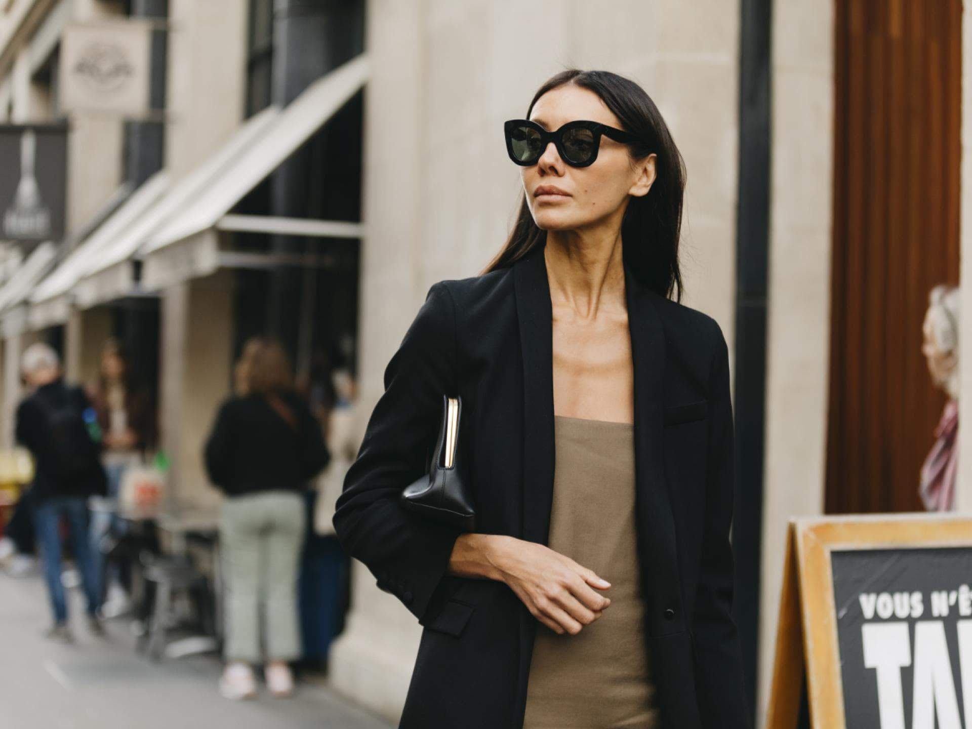 Paris Fashion Week Frau trägt schwarzen Mantel und Sonnenbrille