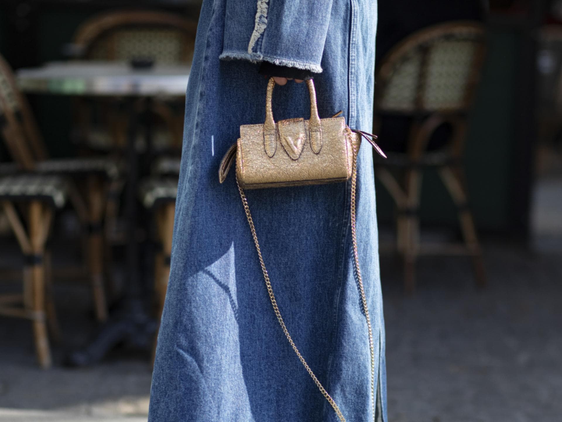 Frau trägt Jeansmantel Jeansschuhe Streetstyle goldene Tasche Frau trägt Jeansmantel Jeansschuhe Streetstyle goldene Tasche