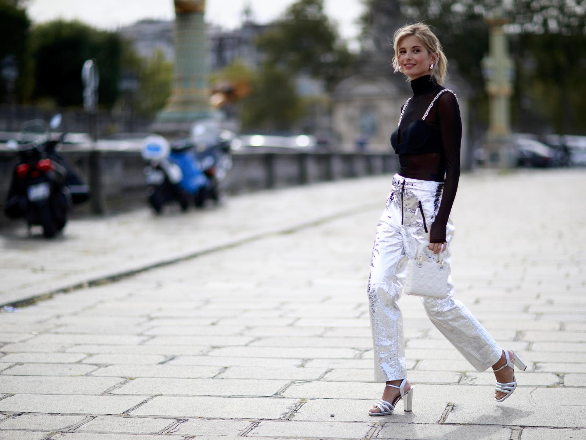 Xenia Adonts trägt eine silberne Hose mit schwarzen Oberteil
