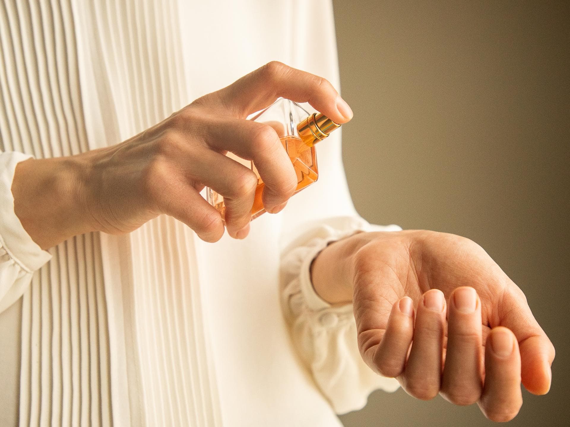 Frau trägt Parfum auf