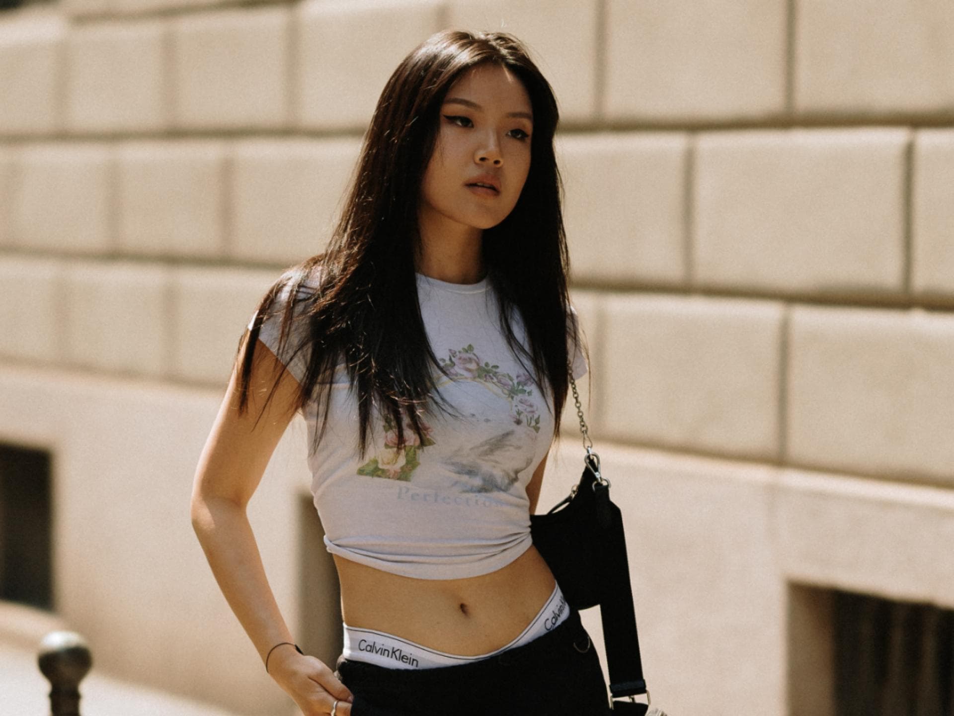 Streetstyle Mailand Fashion Week Frau trägt Rock und Shirt und Boots