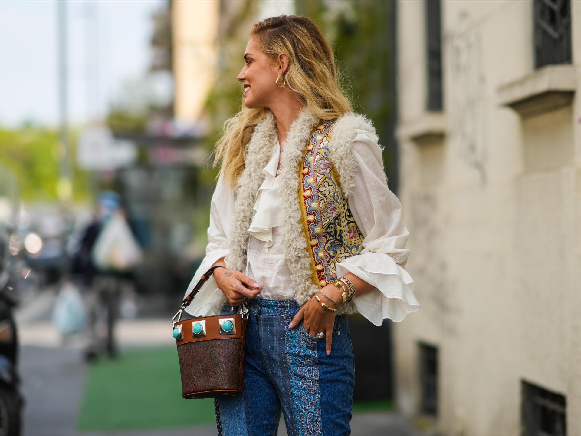 Chiara trägt eine bestickte Weste über eine luftige Bluse