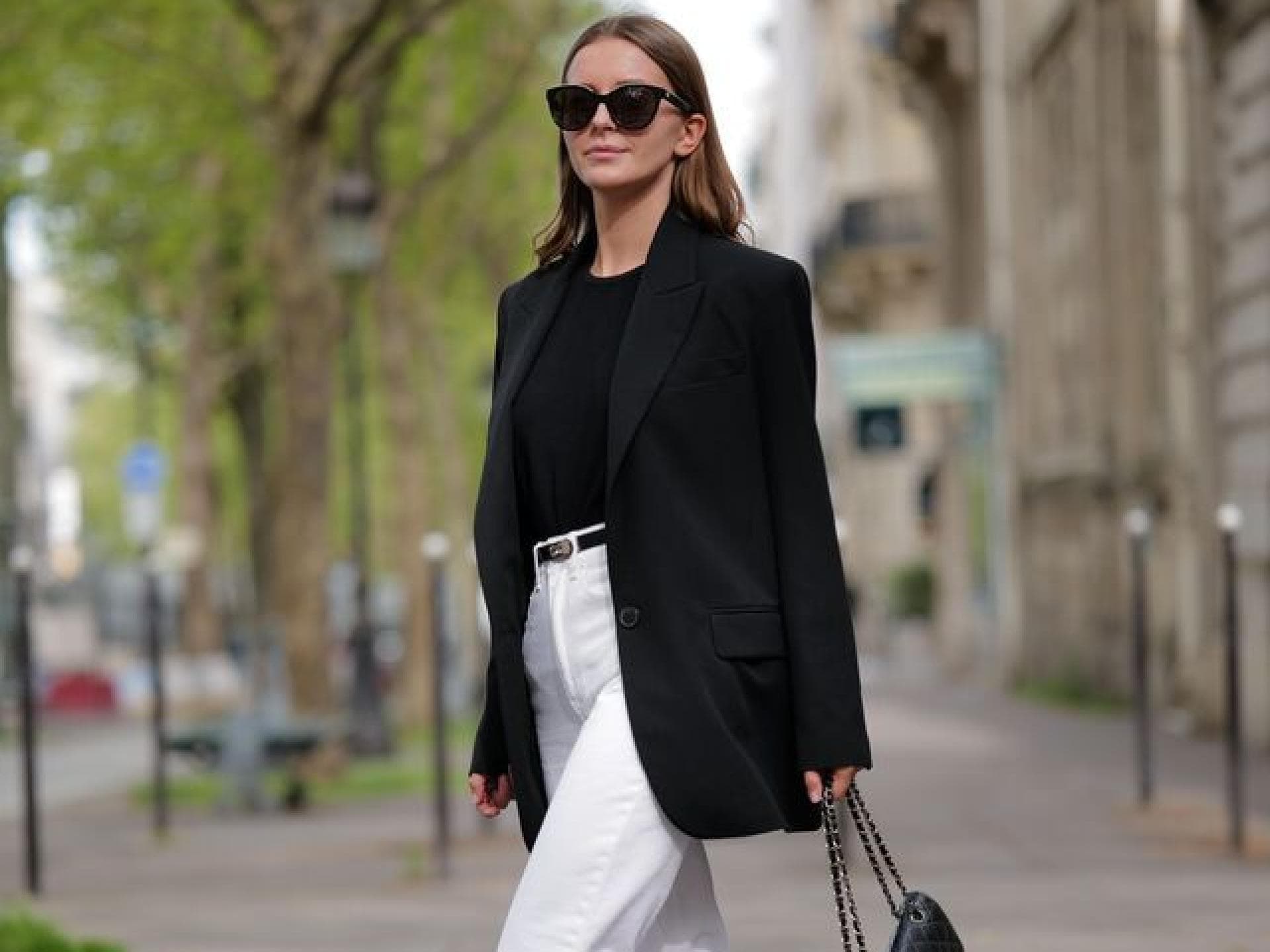 Frau trägt schwarzen Blazer und weiße Jeans