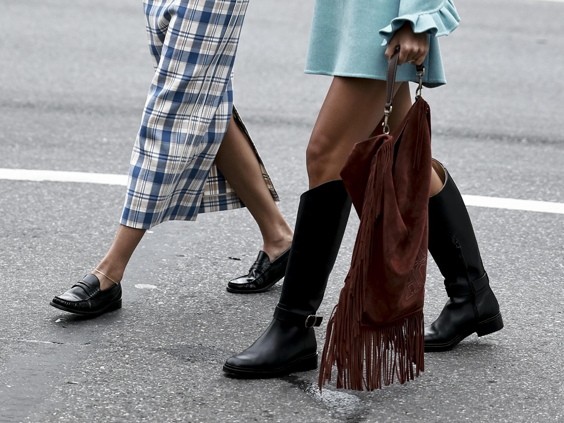 Eine Frau trägt schwarze Loafer und ein Kleid