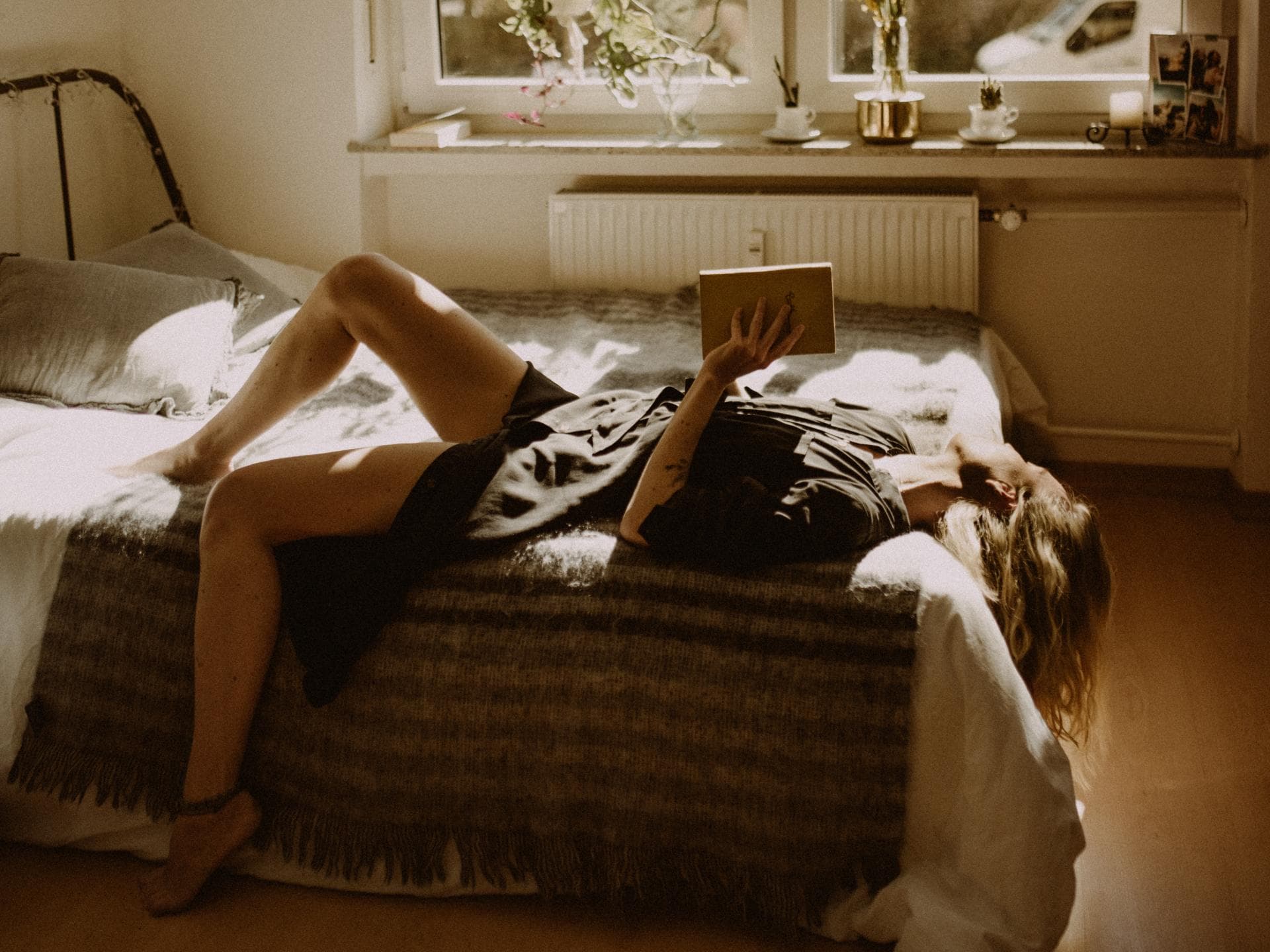 Frau auf dem Bett mit einem Buch in der Hand