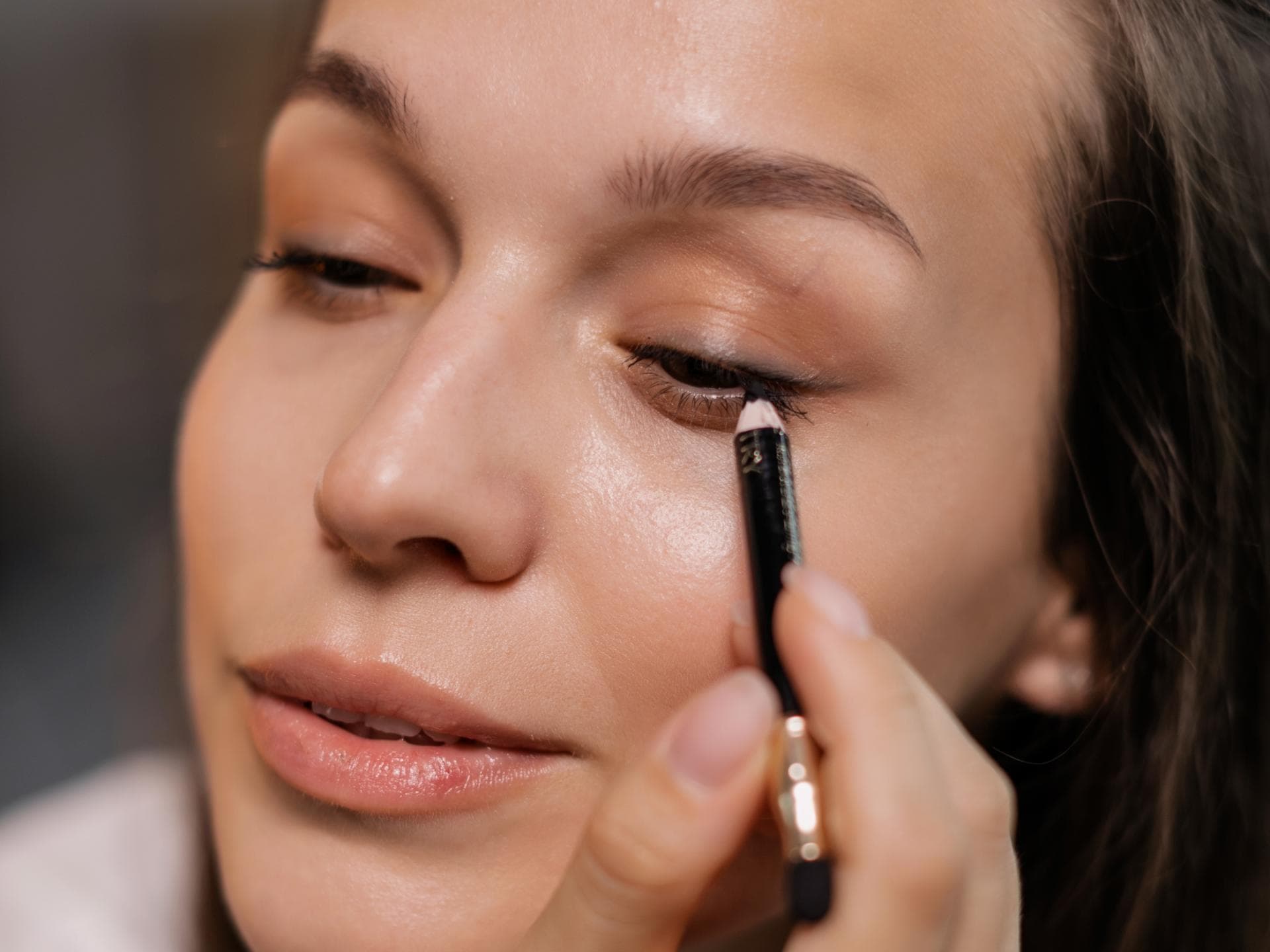 Frau trägt schwarzen Eyeliner auf