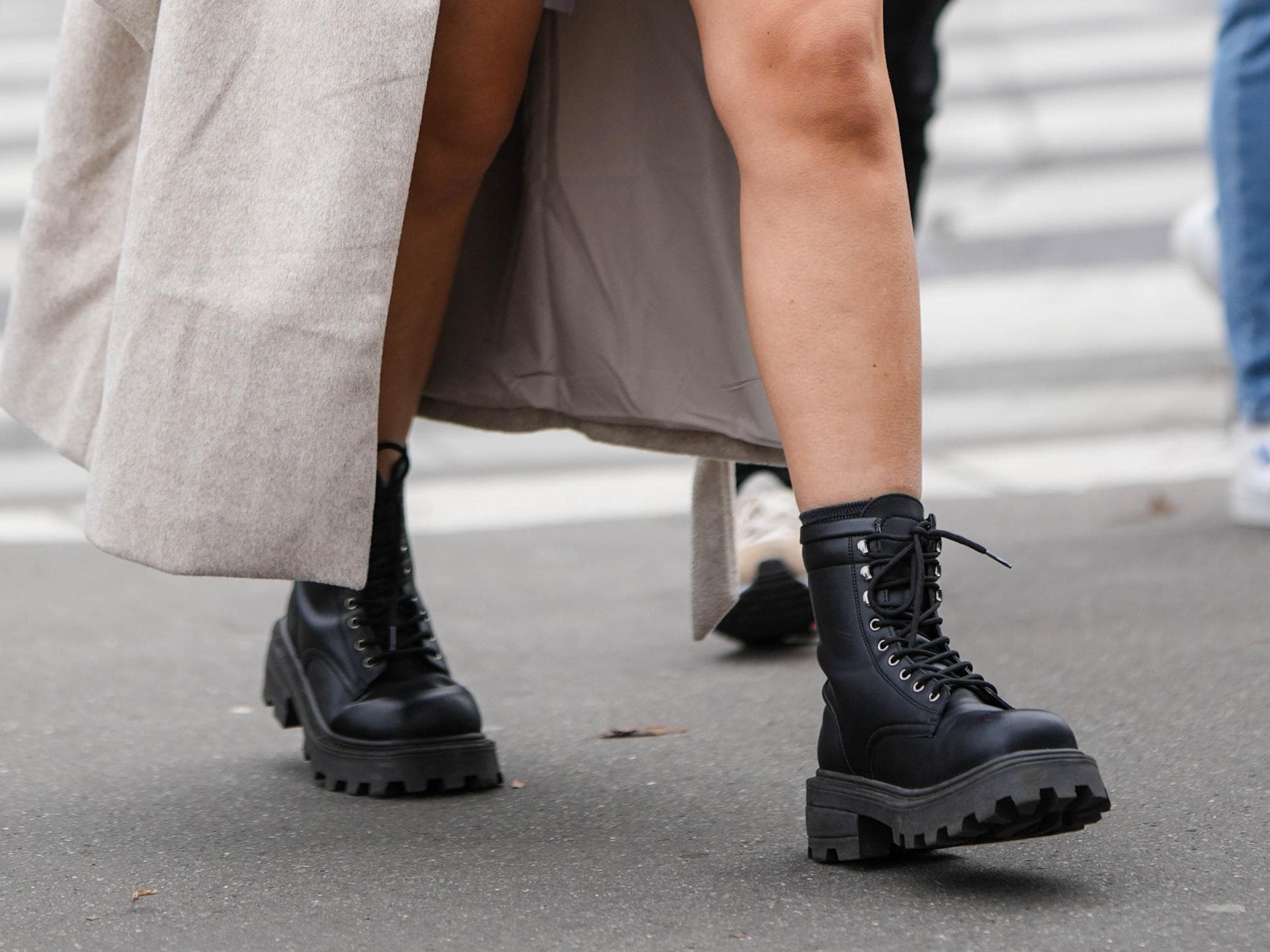 Eine Frau trägt einen Minirock und Schnürstiefel