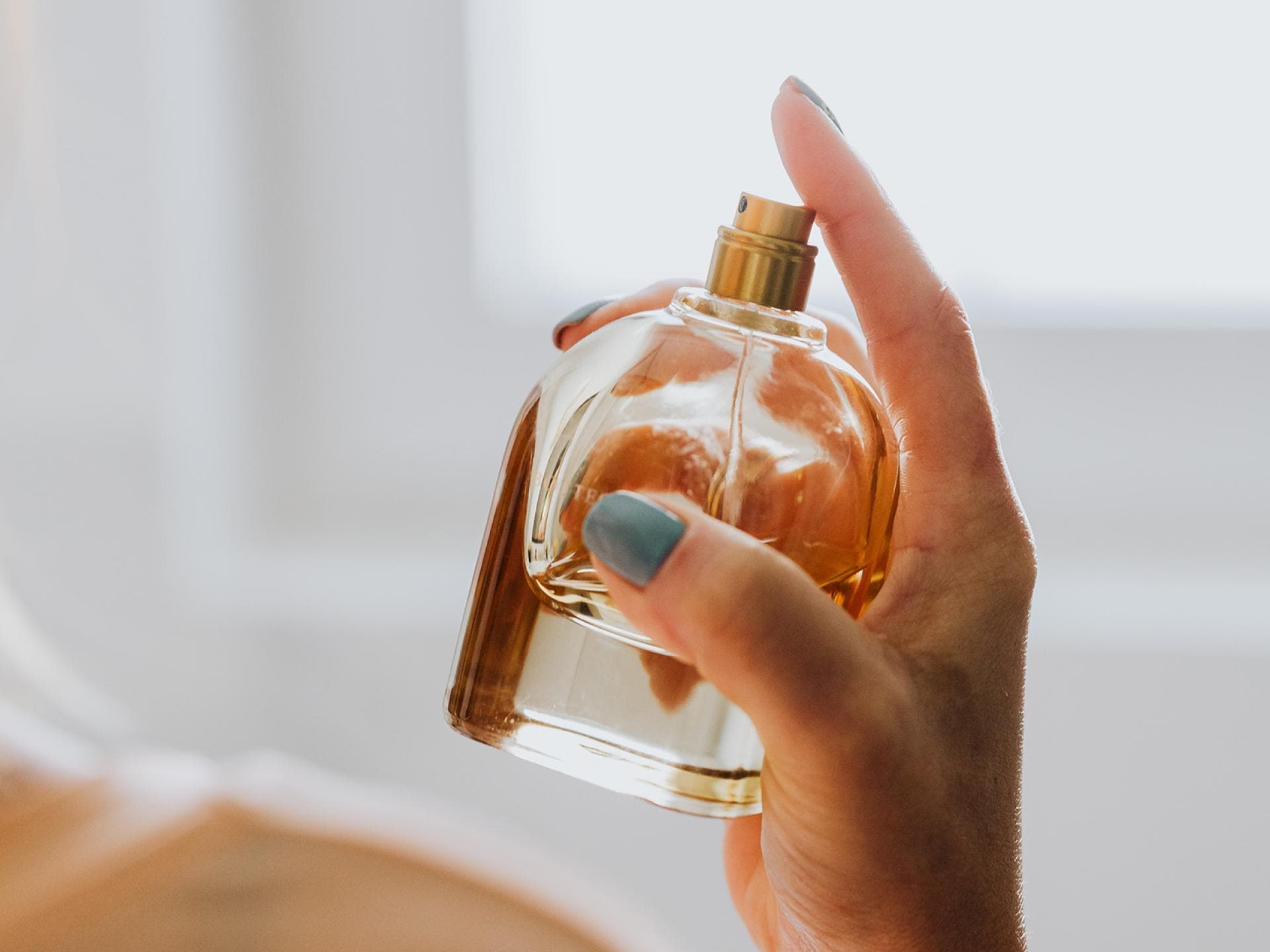 Frau hält Parfum in der Hand