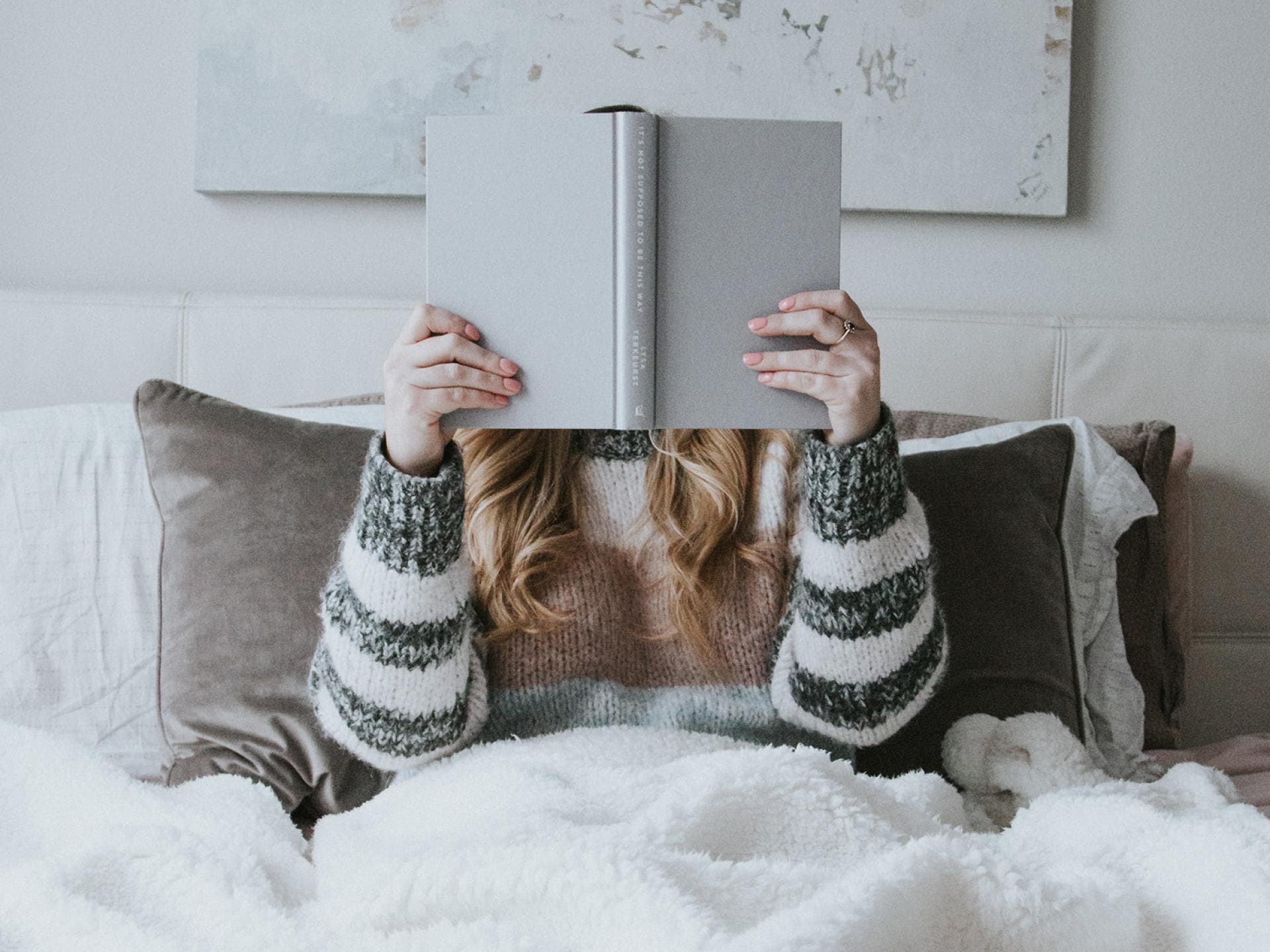 Frau liest ein Buch im Bett
