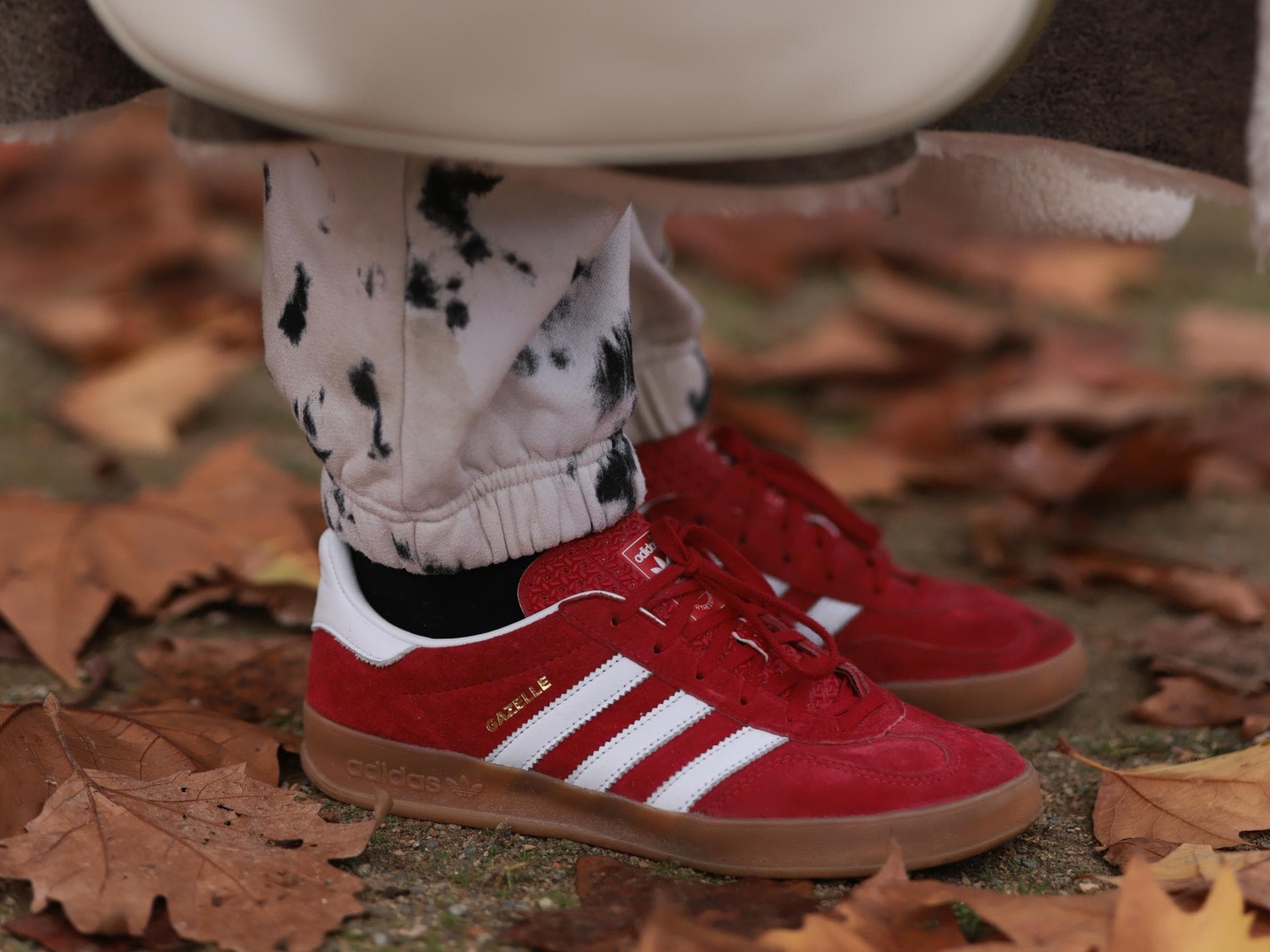 Rote Sneaker von Adidas sind der Schuh-Trend im Herbst Frau trägt rote Adidas Sneaker