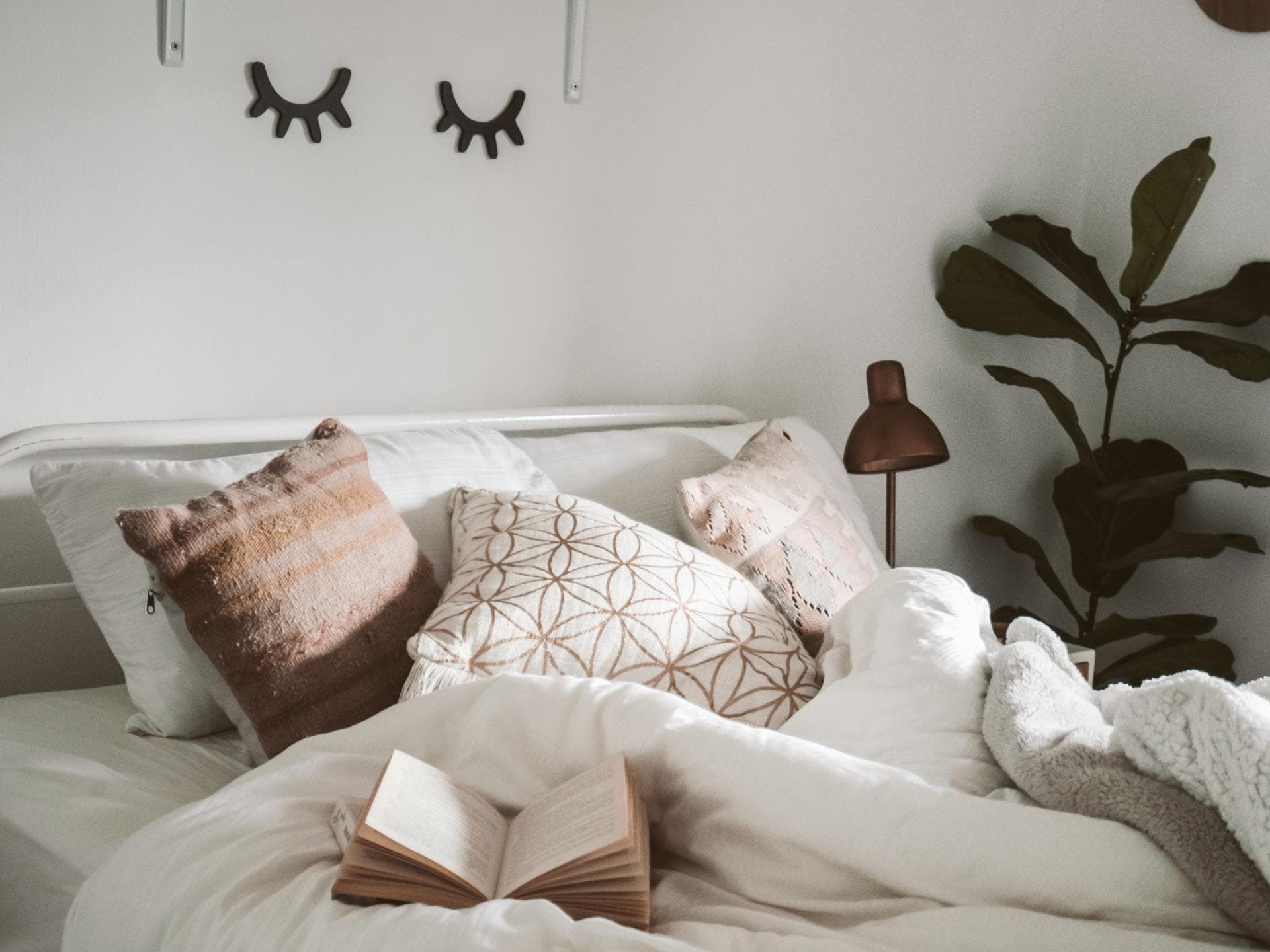 Bett mit weißer Bettwäsche im Schlafzimmer