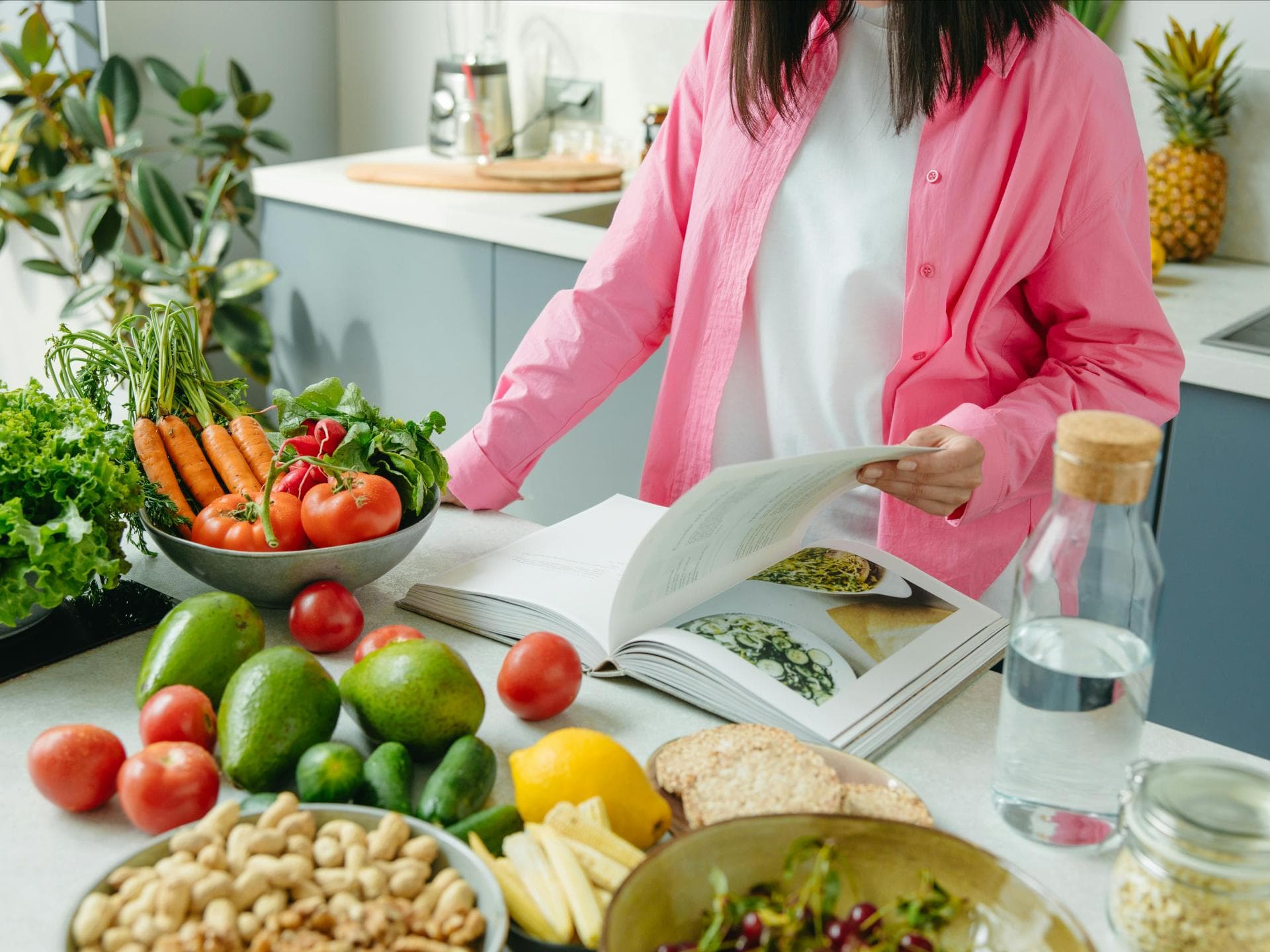 Frau kocht vegan mit Kochbuch