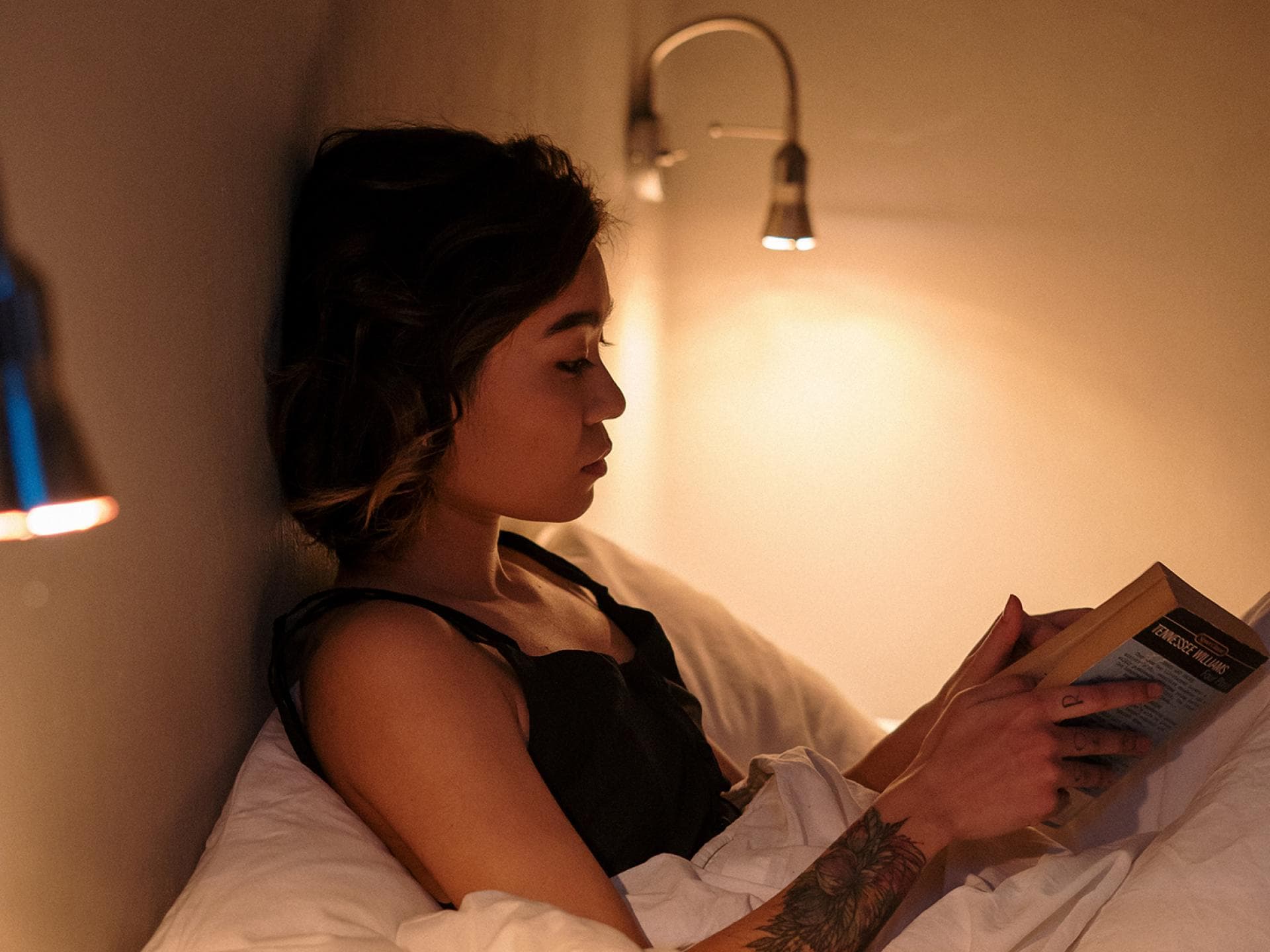 Frau liest Buch im Bett