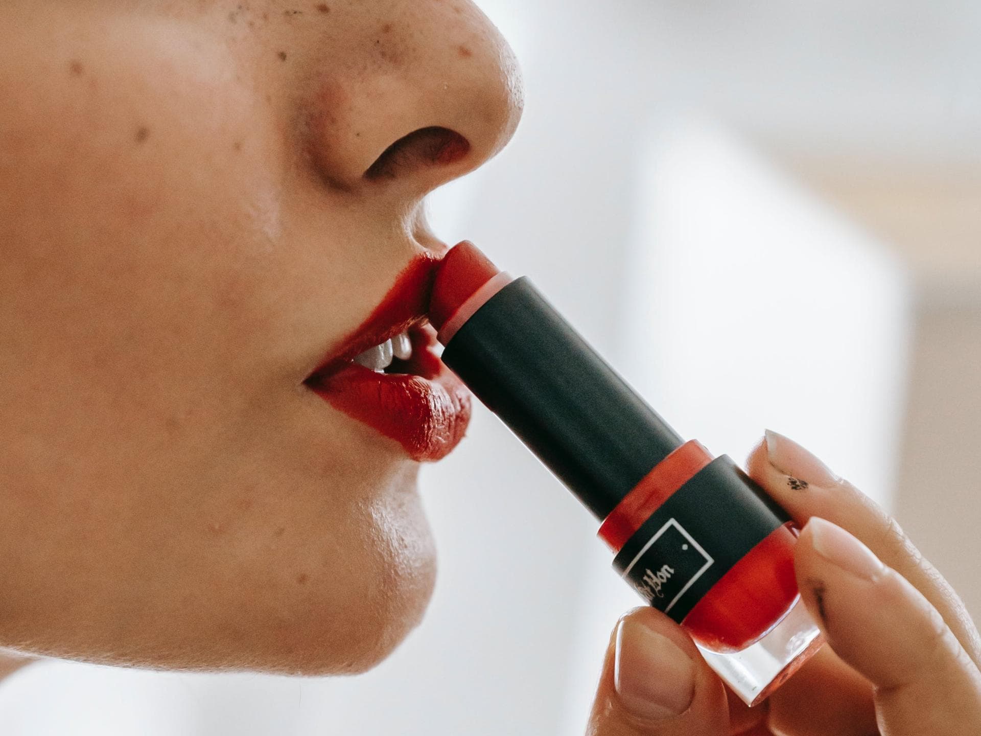 Frau trägt Lippenstift auf