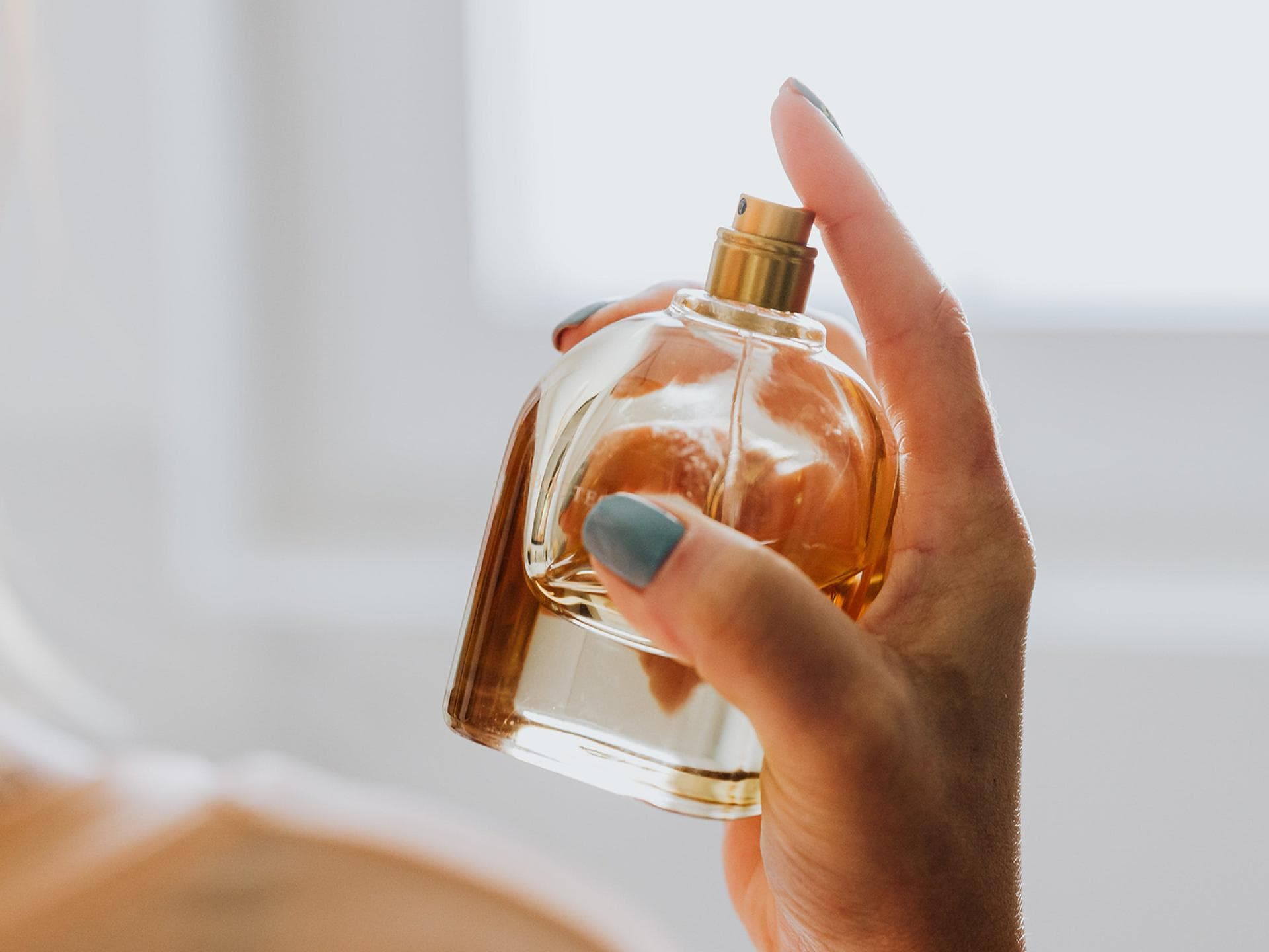 Frau trägt Parfum auf