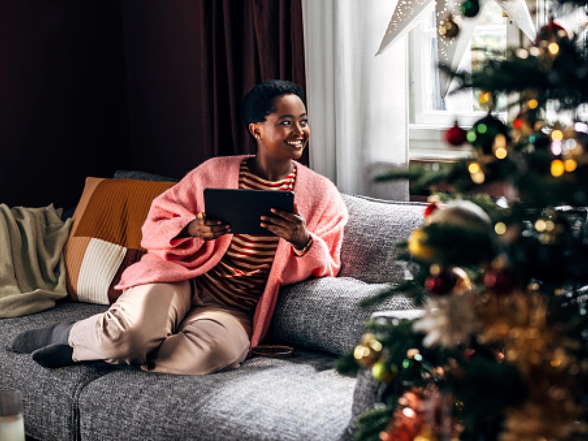 Frau hat Me Time und sitzt vor dem Weihnachtsbaum