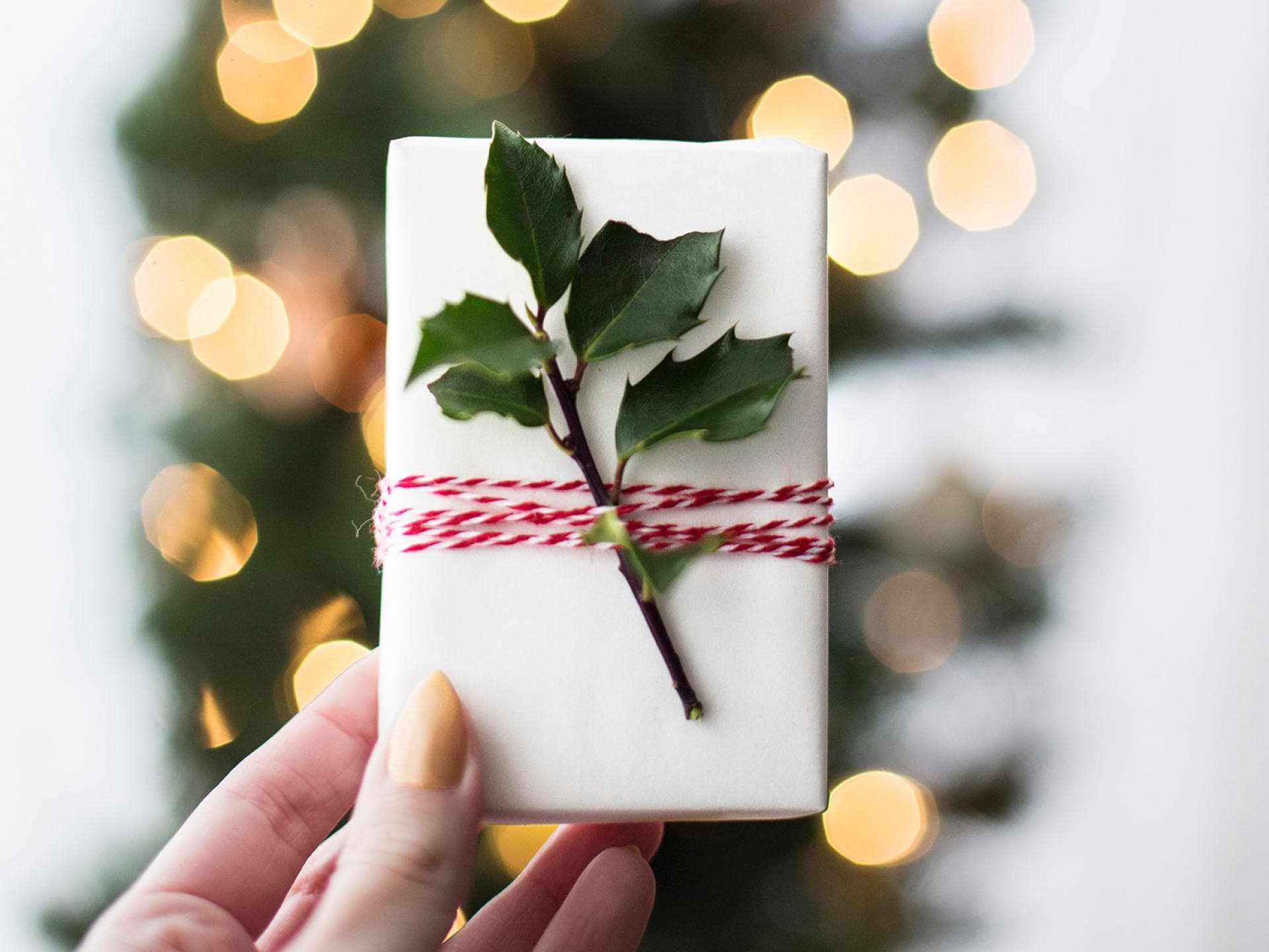 Frau hält Weihnachtsgeschenk in der Hand Frau hält Weihnachtsgeschenk in der Hand