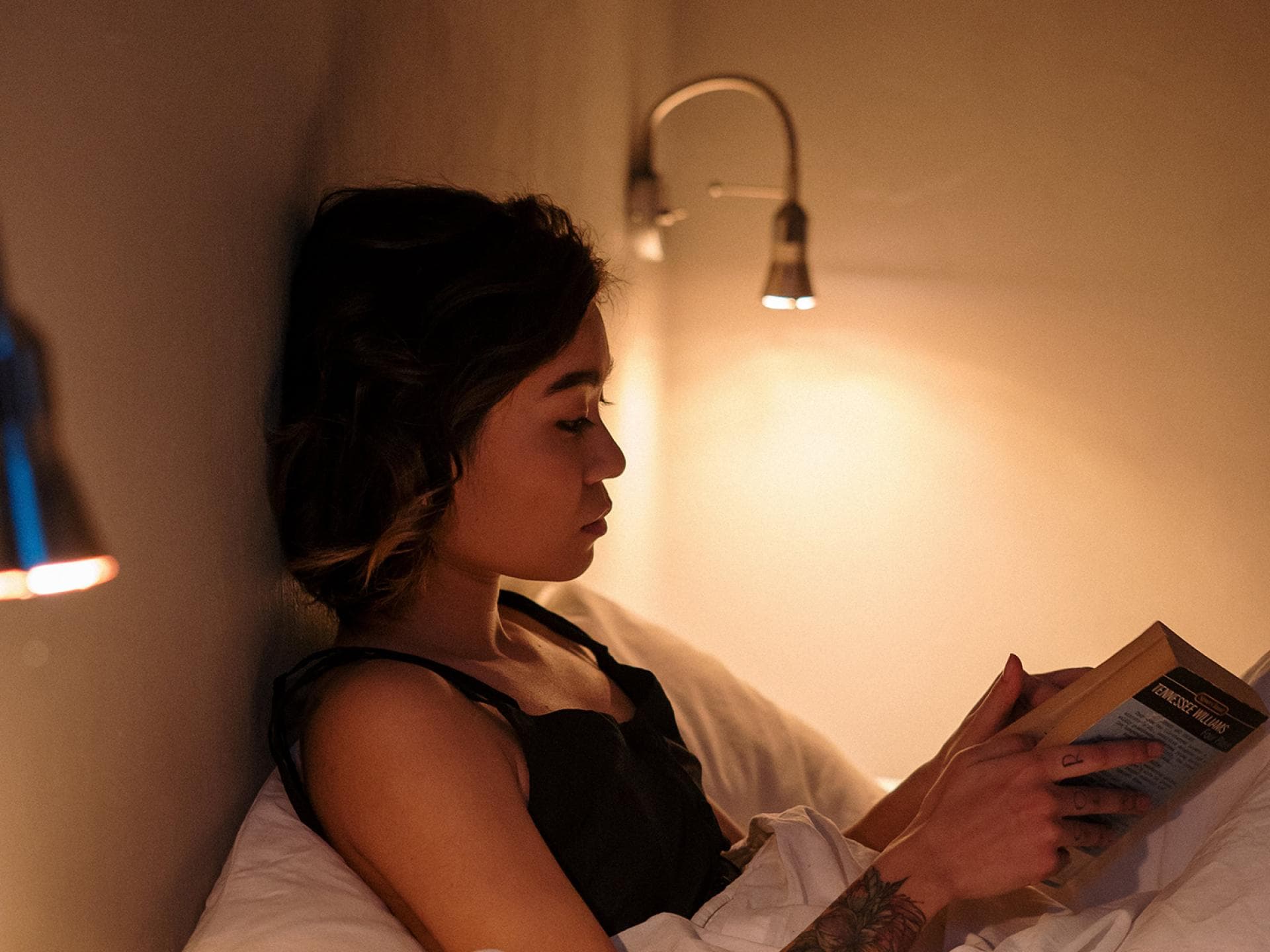 Frau liest Buch im Bett