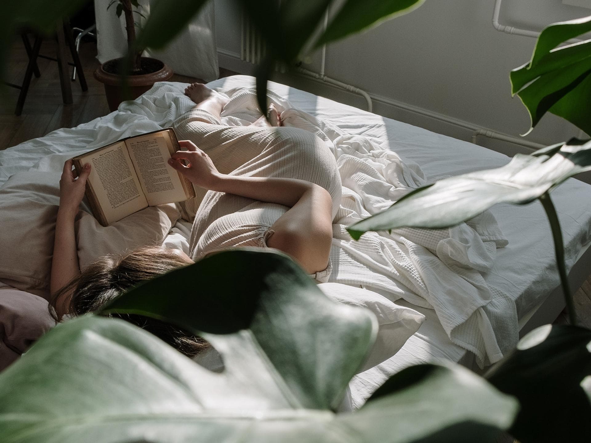 Frau liest Buch im Bett