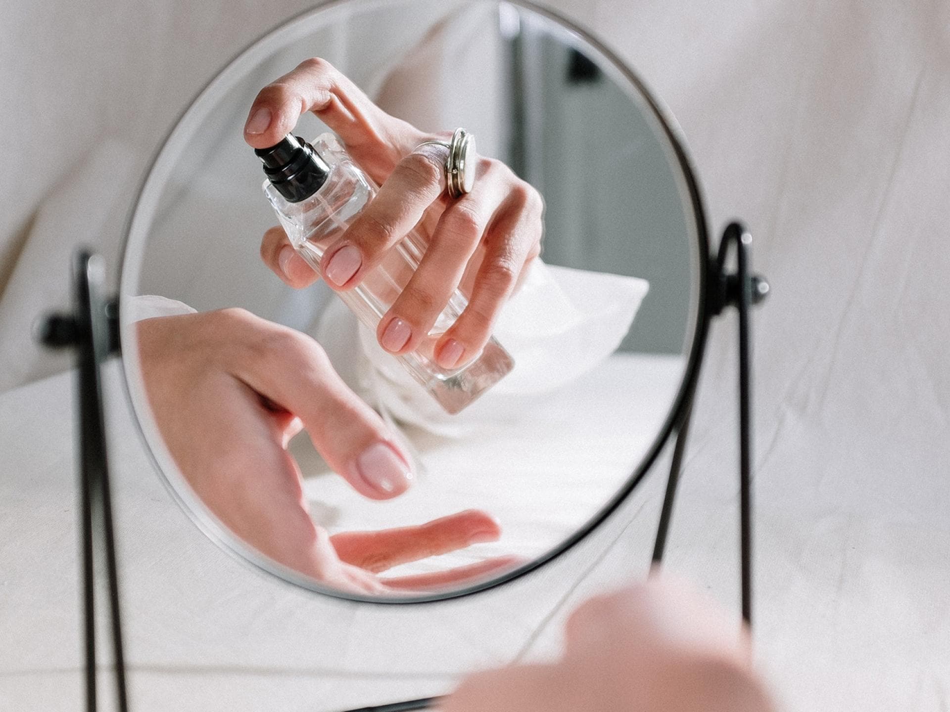 Frau trägt Parfum aufs Handgelenk auf Frau trägt Parfum aufs Handgelenk auf