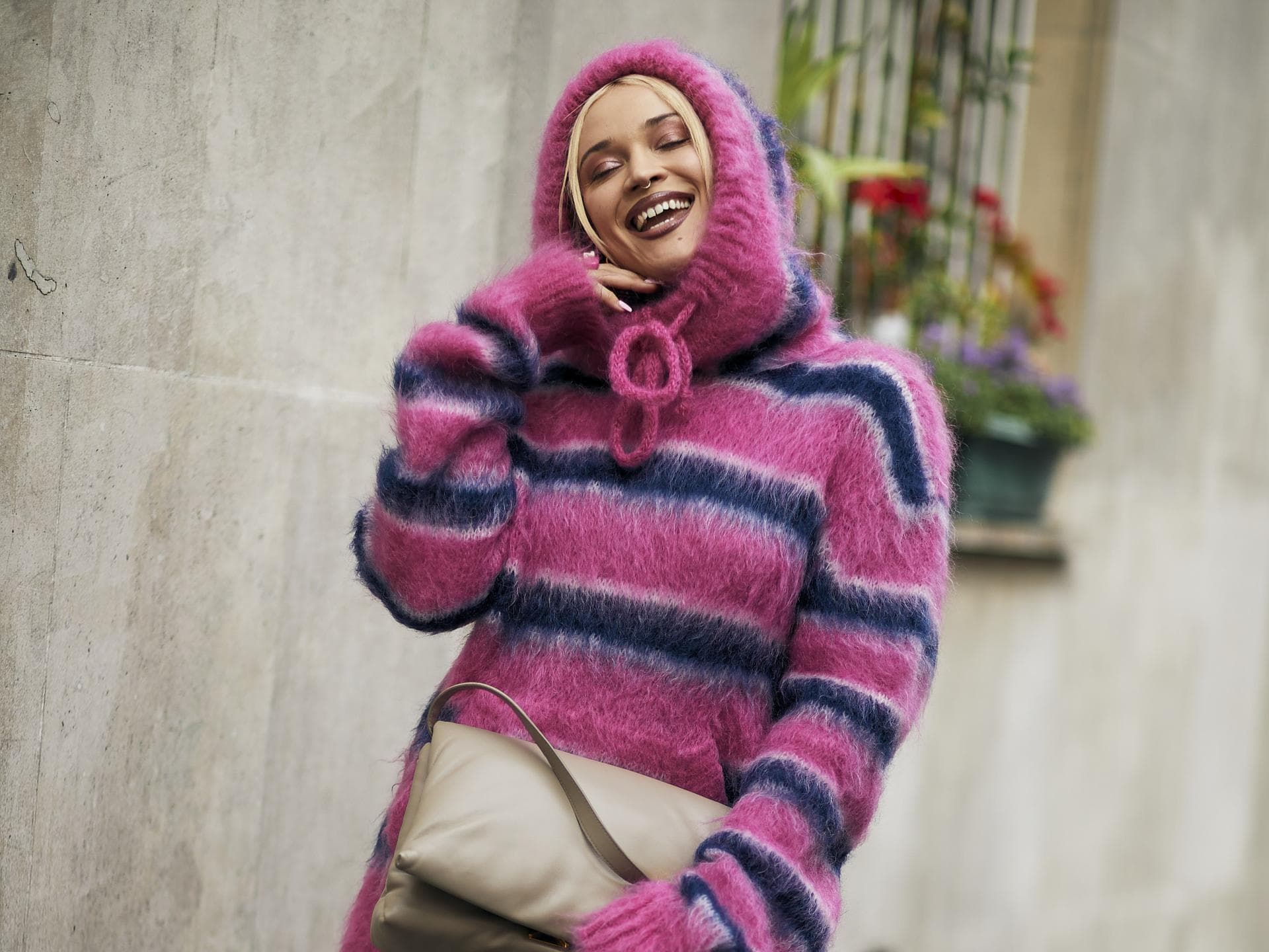Frau im Oversize Strickpullover und Jeansshorts Frau auf Paris Fashion Week im Oversize Strickpullover und Jeansshorts