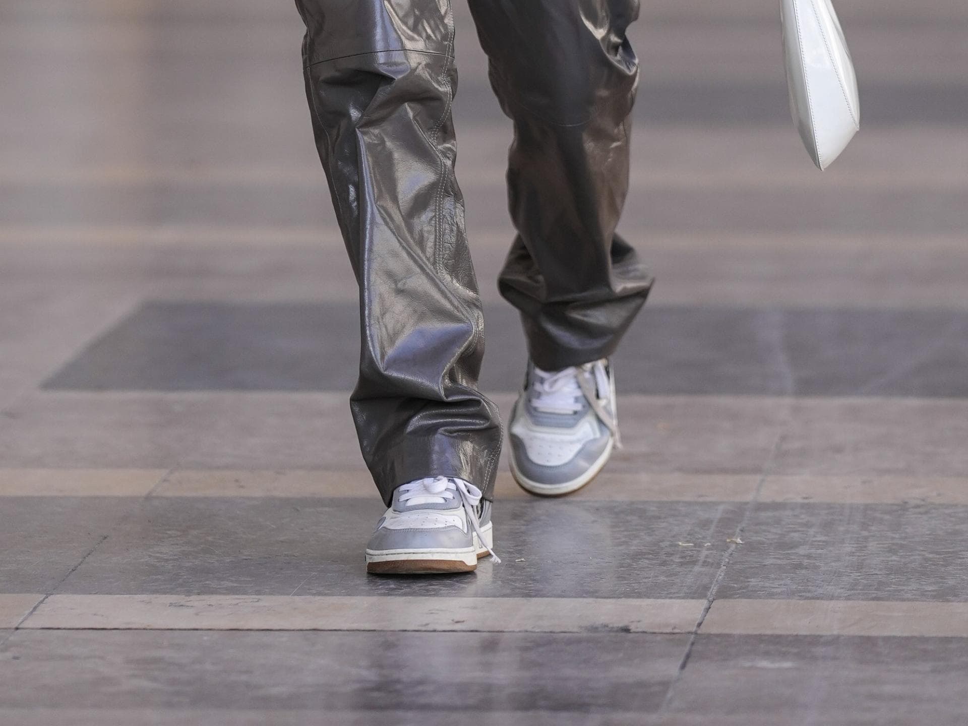 Frau trägt grau-weiße Sneaker