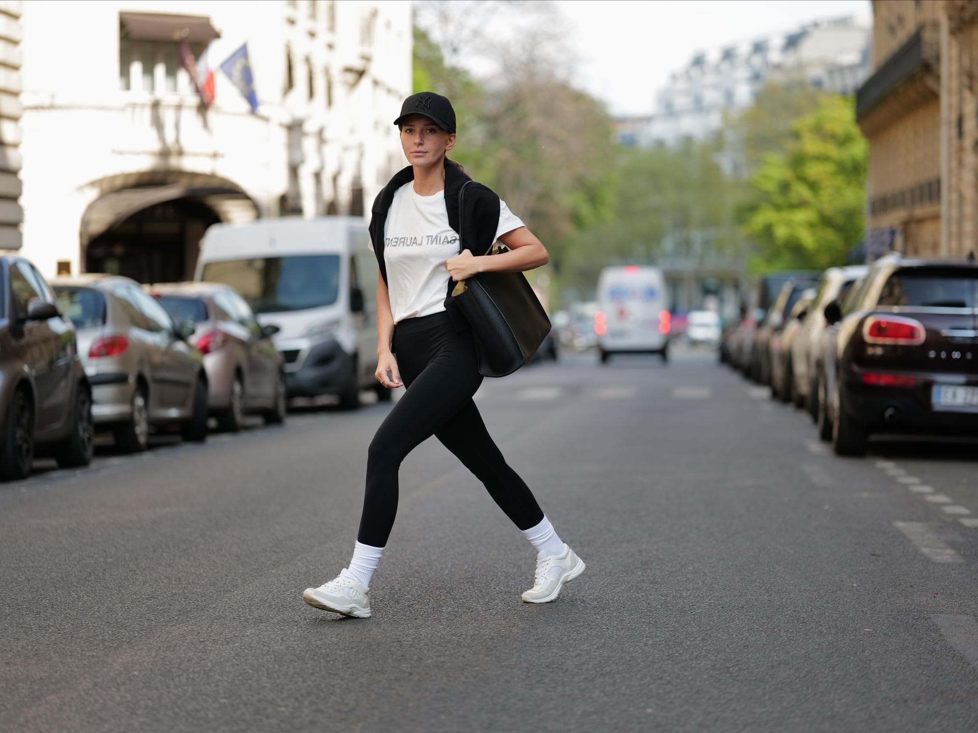 Diane Batoukina trägt schwarze Sport-Leggings weißes T-Shirt schwarze Cap und schwarze Tasche Diane Batoukina trägt schwarze Sport-Leggings weißes T-Shirt schwarze Cap und schwarze Tasche