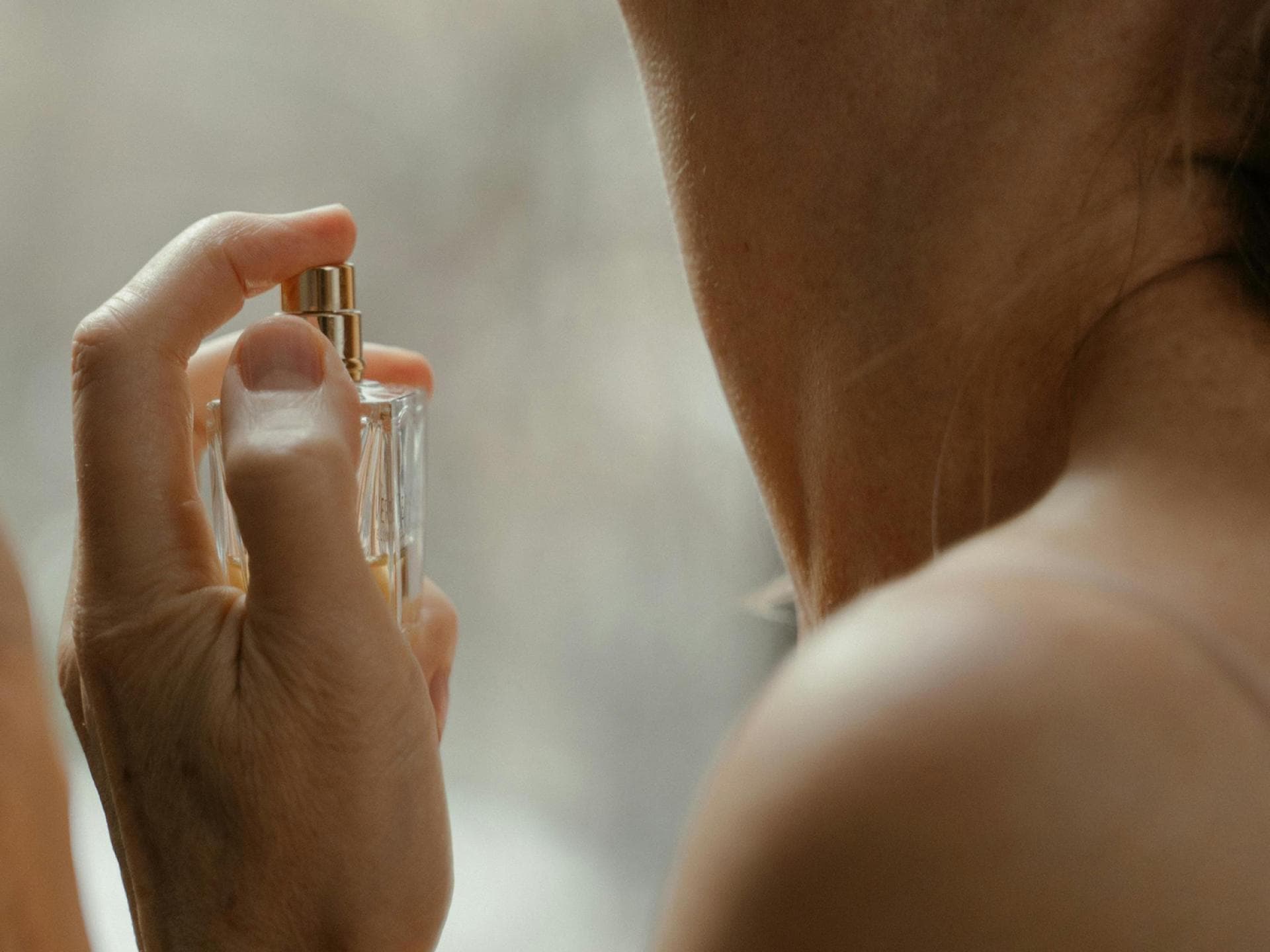 Frau trägt Parfum auf