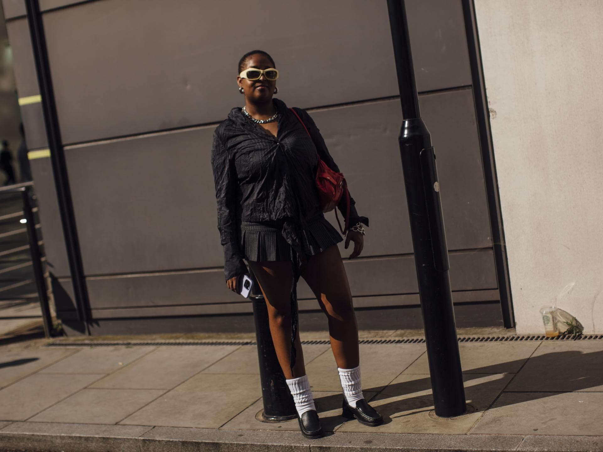 So müssen Röcke jetzt aussehen, um im Trend zu liegen – 3 Must-haves Frau trägt auf London Fashion Week Minirock mit Nadelstreifen