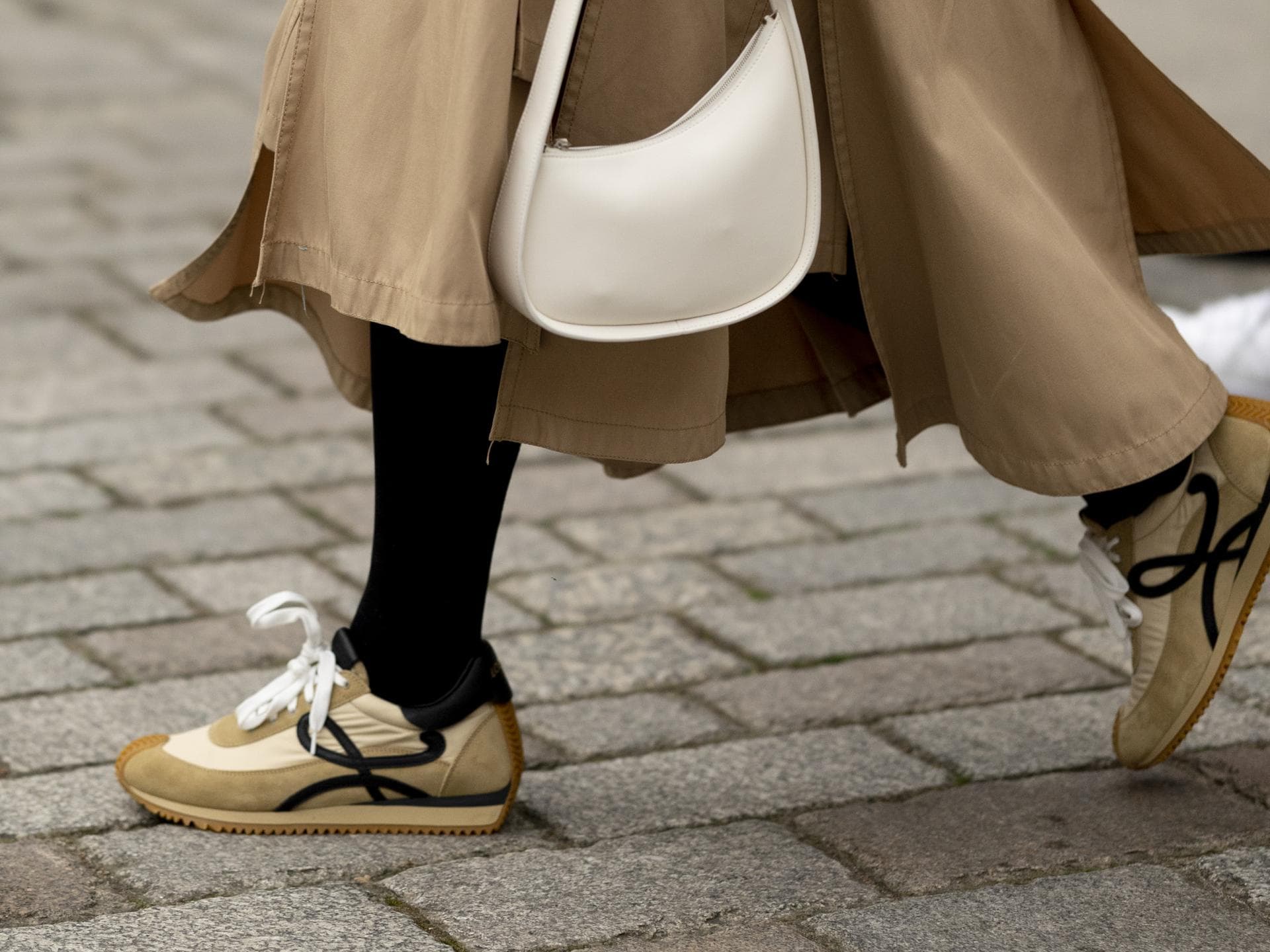 London Fashion Week Frau trägt beigefarbenen Sneaker und Rock