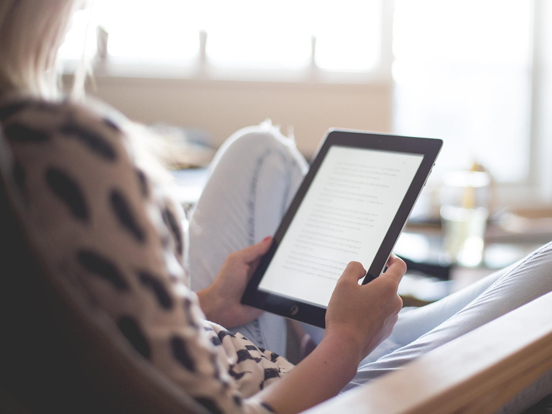 Frau liest Buch auf dem Reader