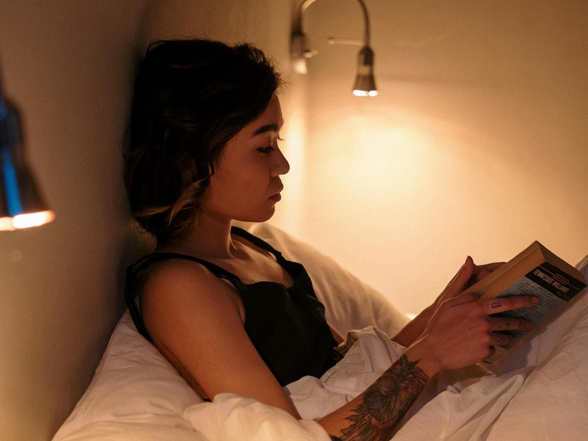 Frau liest Buch Frau liest im Bett ein Buch.