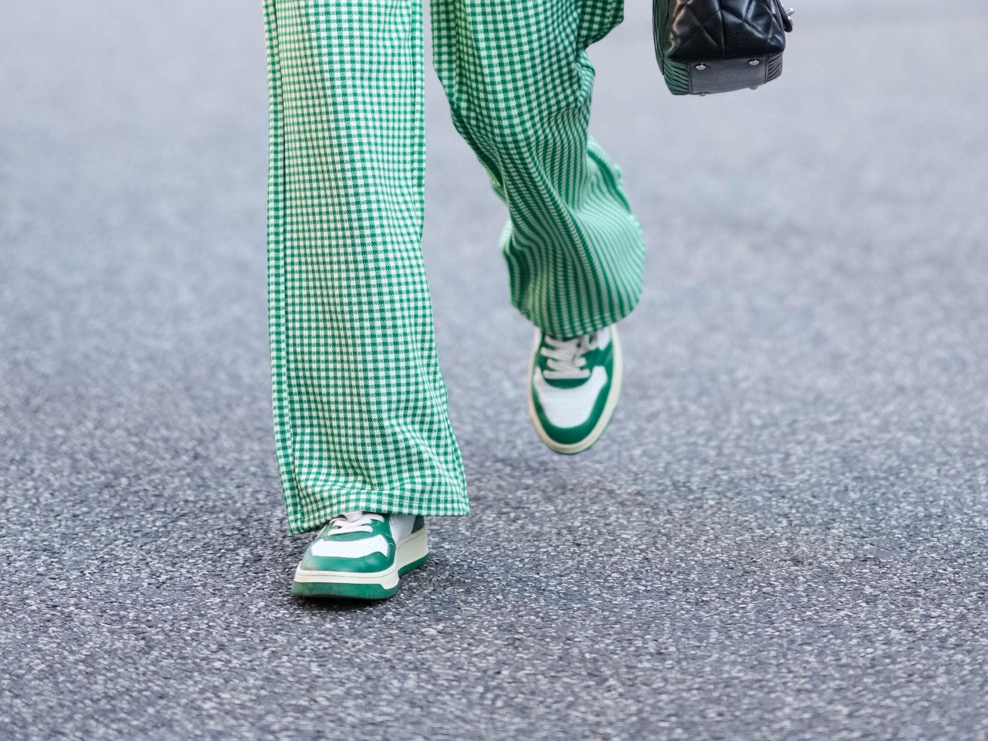 Frau trägt Hosenanzug und grüne Sneaker 