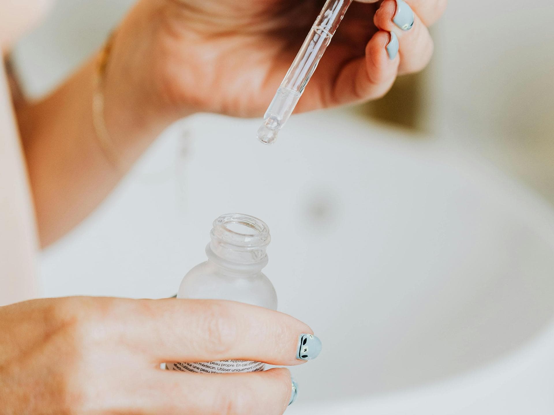 Wirkstoffe gegen Akne Frau hält Serum in der Hand