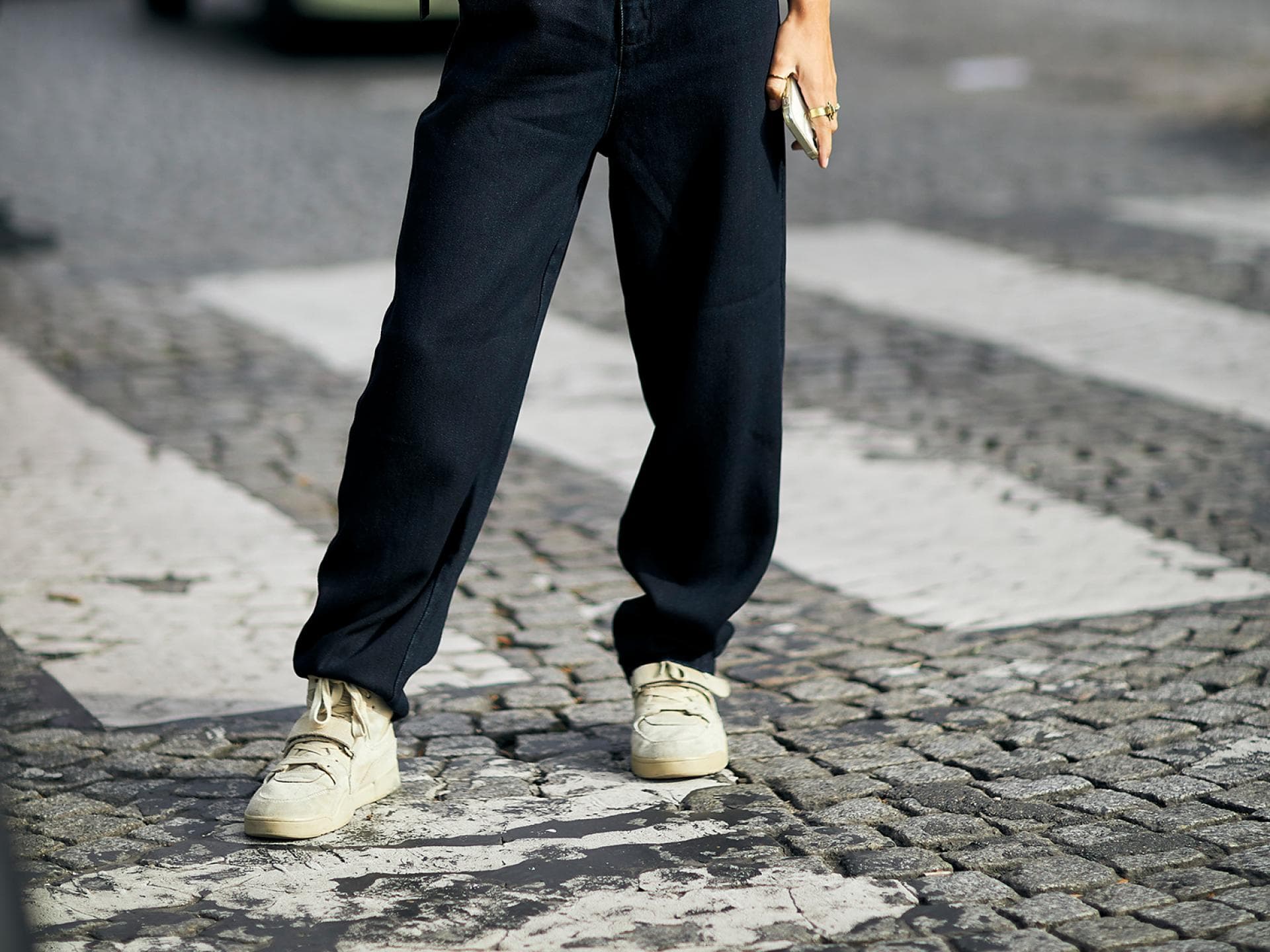 Frau mit schwarzem Outfit und Sneakern Frau mit schwarzem Outfit und Sneakern