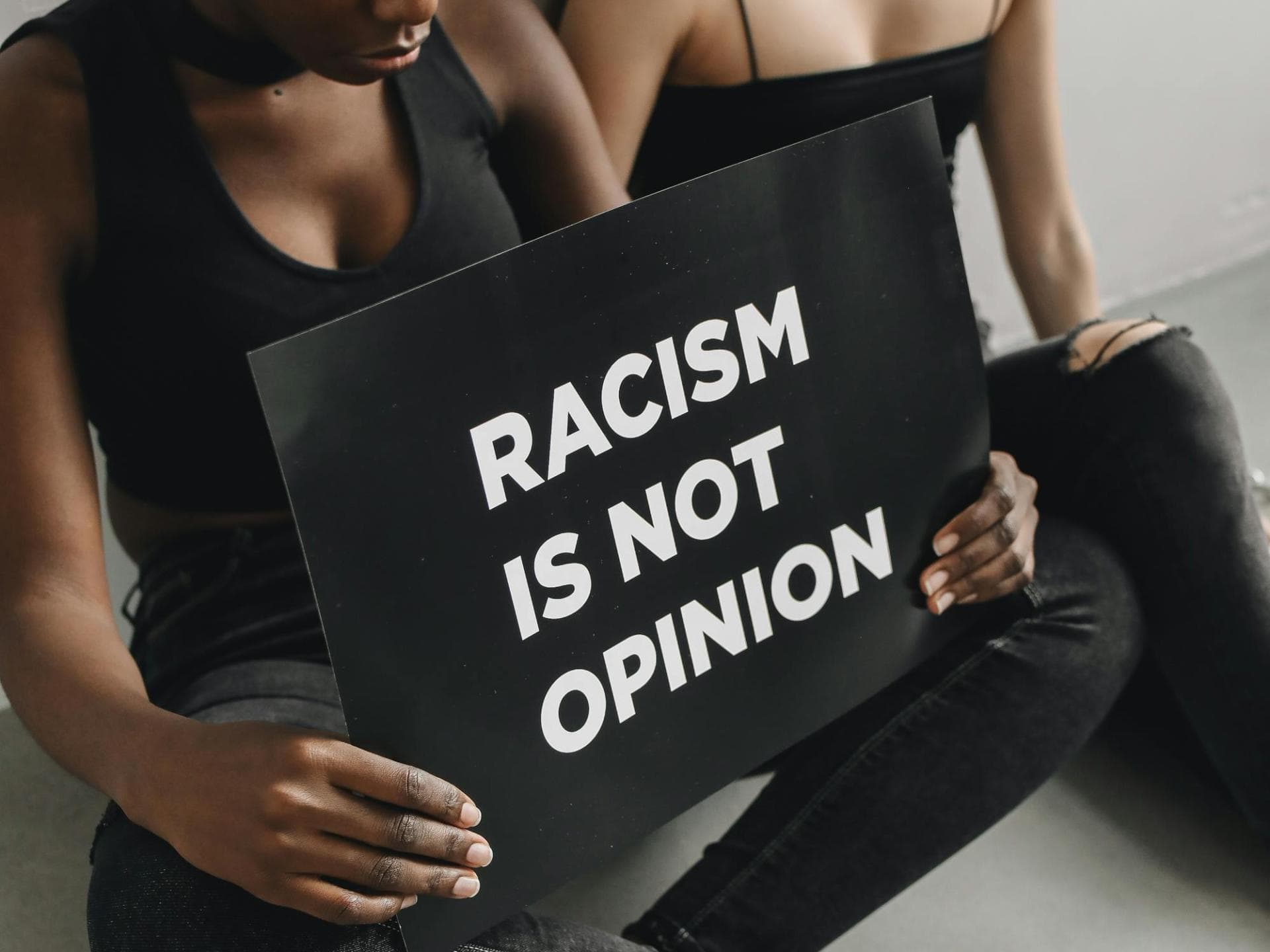 Zwei Frauen mit Schild "Racism is not opinion" Zwei Frauen mit Schild "Racism is not opinion"