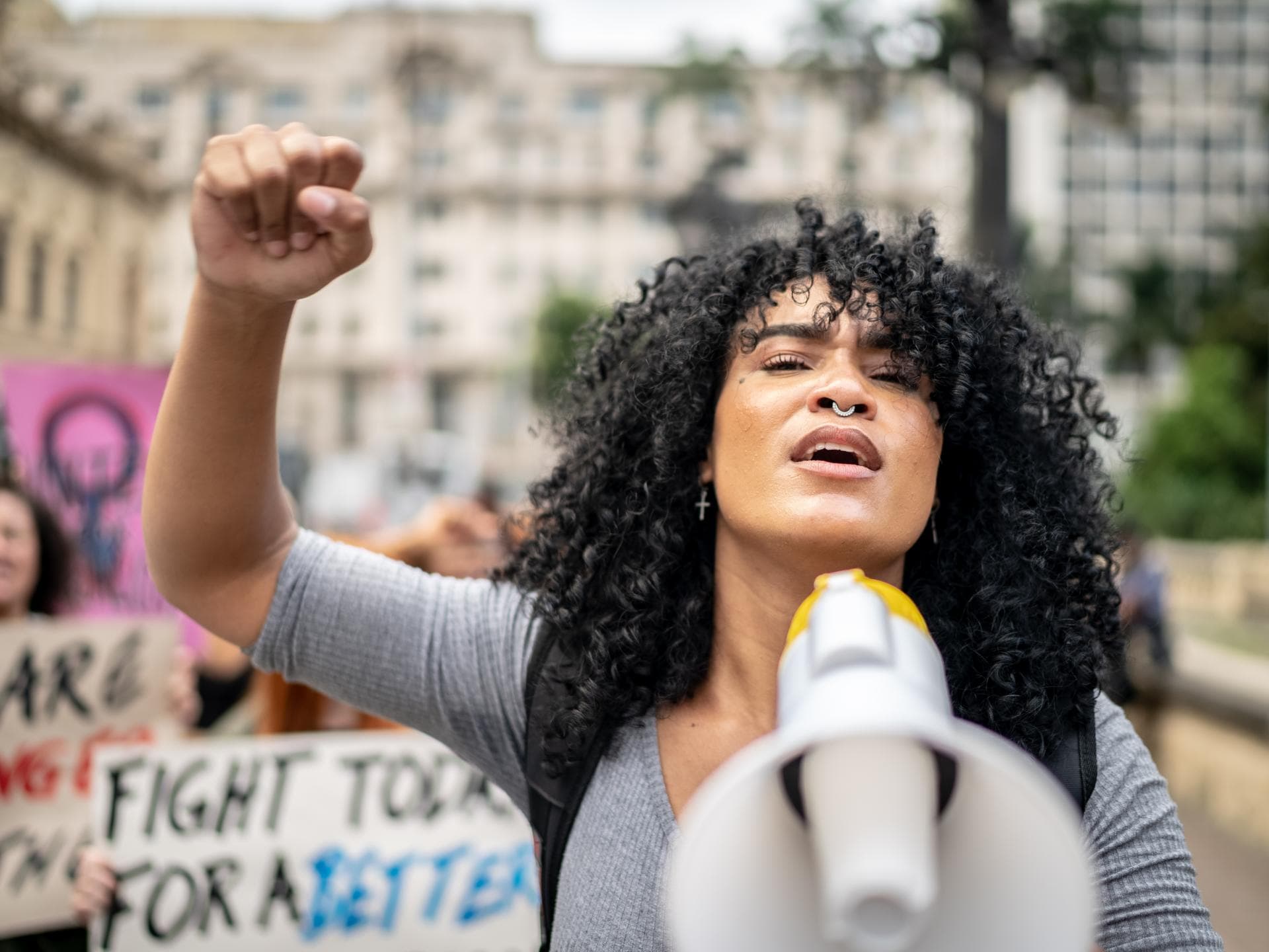 Frau hält Megafon bei Demonstration Frau hält Megafon bei Demonstration