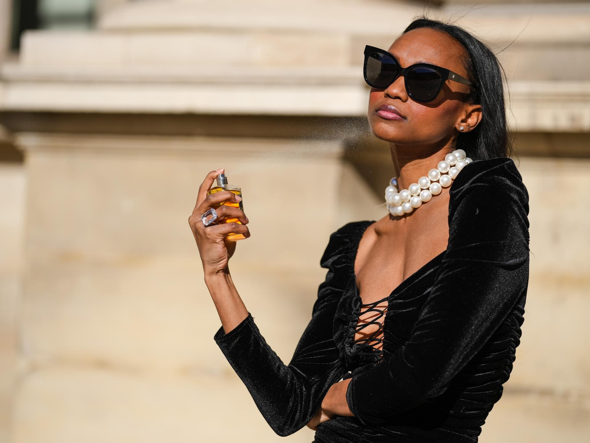 Parfum-Trend: Das ist die passende Duftnote zu deinem Modestil Frau sprüht mit Parfum
