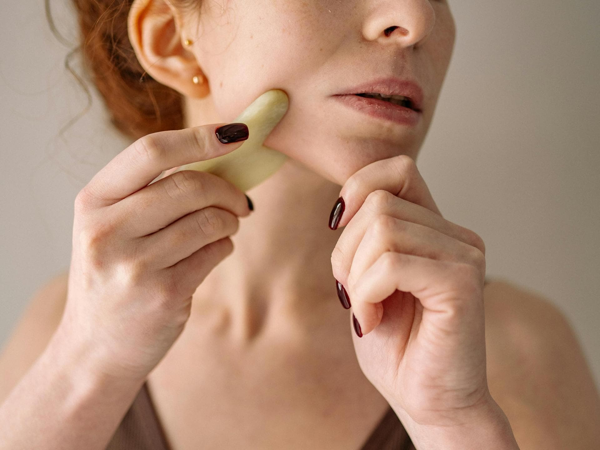 Beauty Tools Frau benutzt Beauty Tool Gua Sha Stein