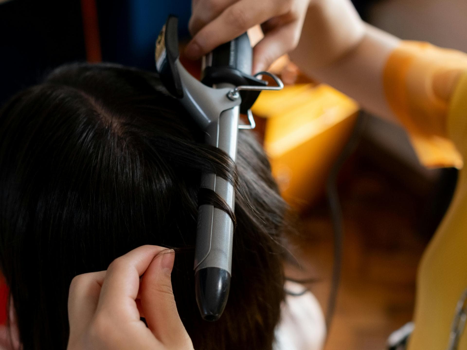 Amazon-Lockenstab Frau lockt Haare mit Lockenstab