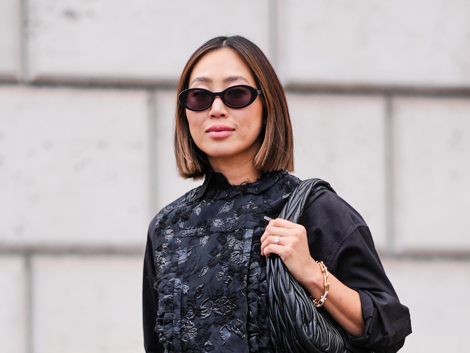 Influencerin Aimee Song mit einem Haarschnitt für dünnes Haar und Sonnenbrille im schwarzen Outfit
