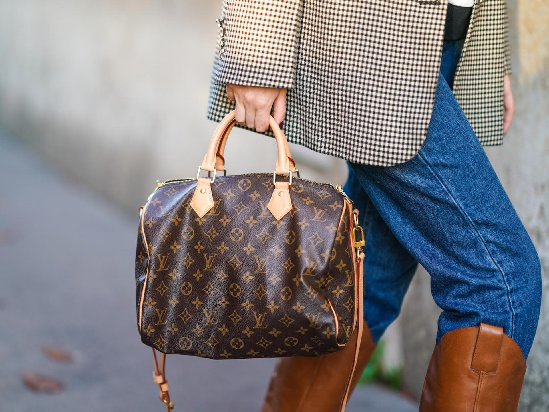 Frau trägt Louis Vuitton Speedy mit Jeans und Stiefeln