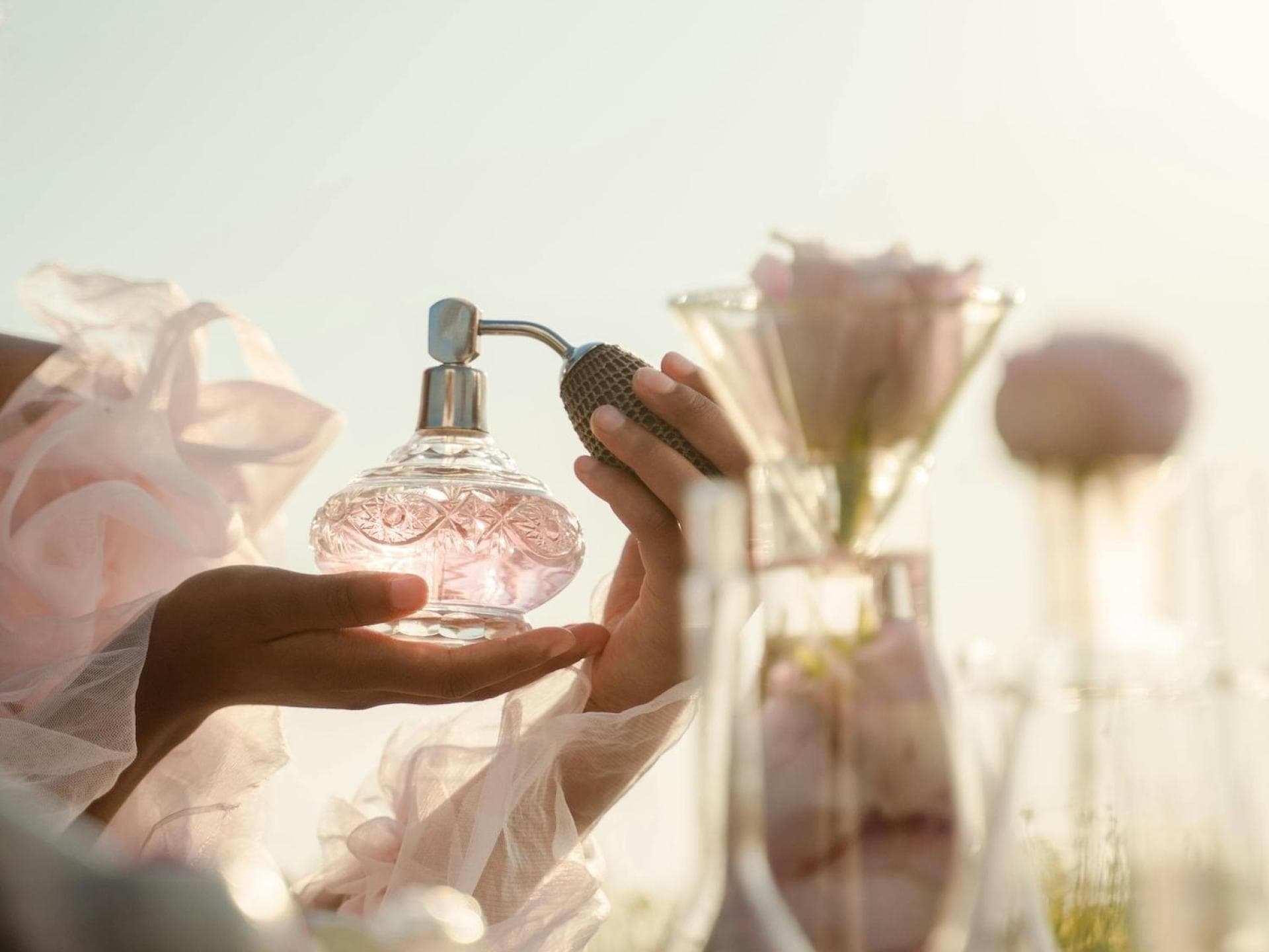 Frau mit einem Parfumflakon in der Hand