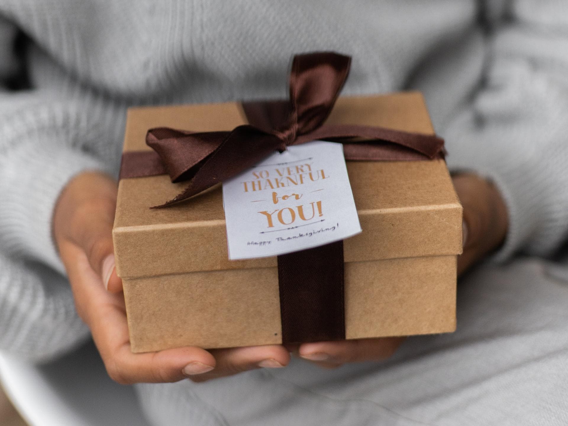 Eine Frau hält ein Geschenk in den Händen