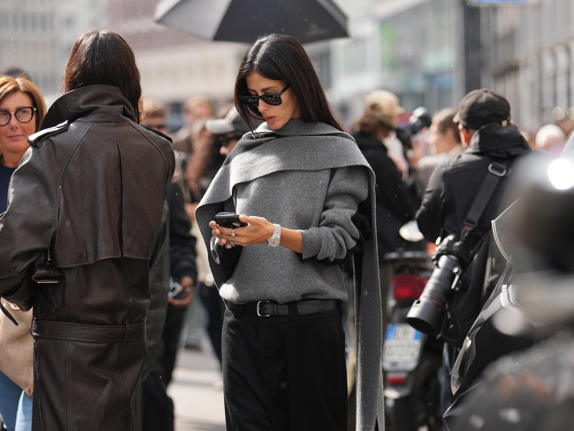 Influencer Herbst-Trends 2025 Frau mit grauem Outfit schaut auf ihr Handy
